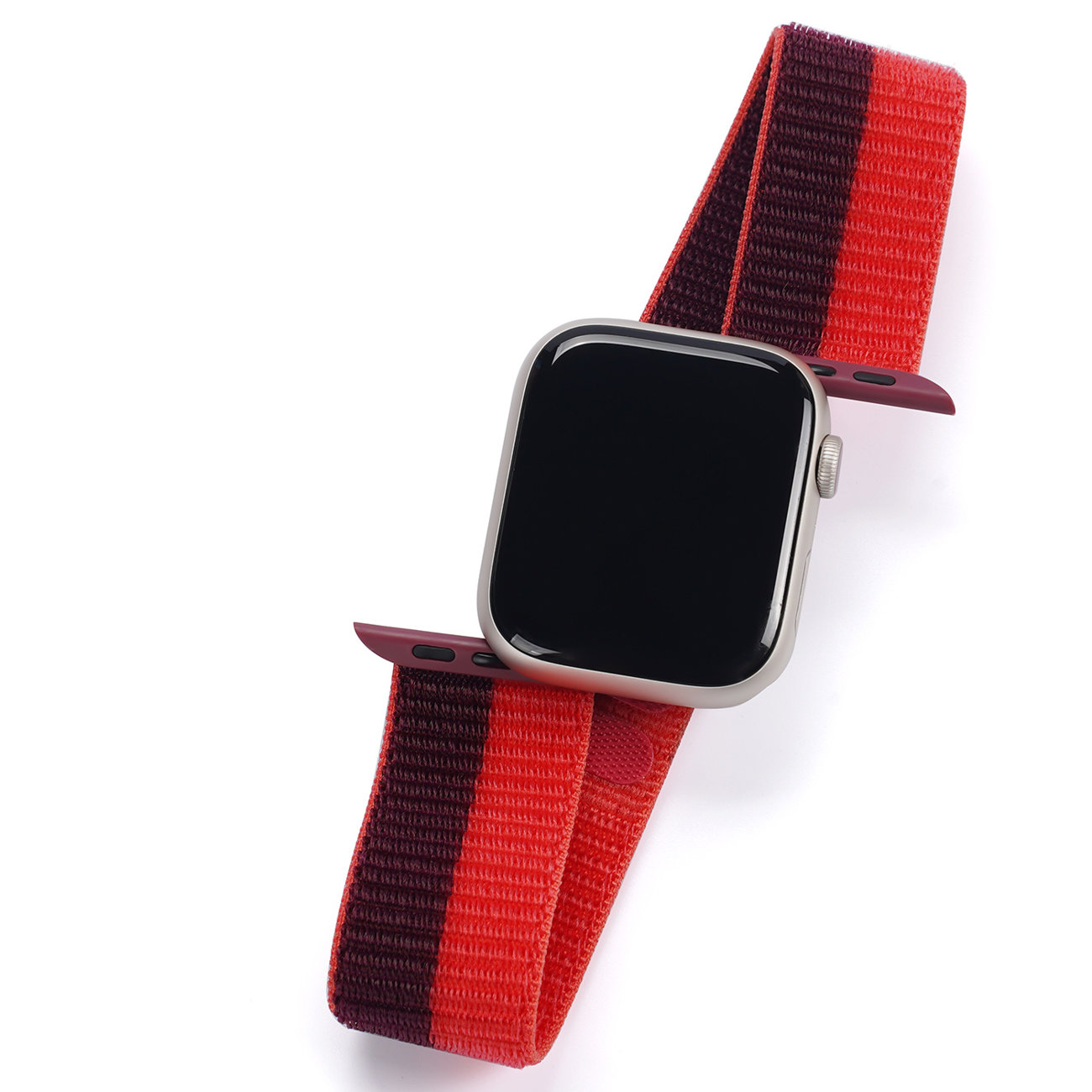 Eine Smartwatch mit einem rot-lila gestreiften Armband auf weißem Untergrund.