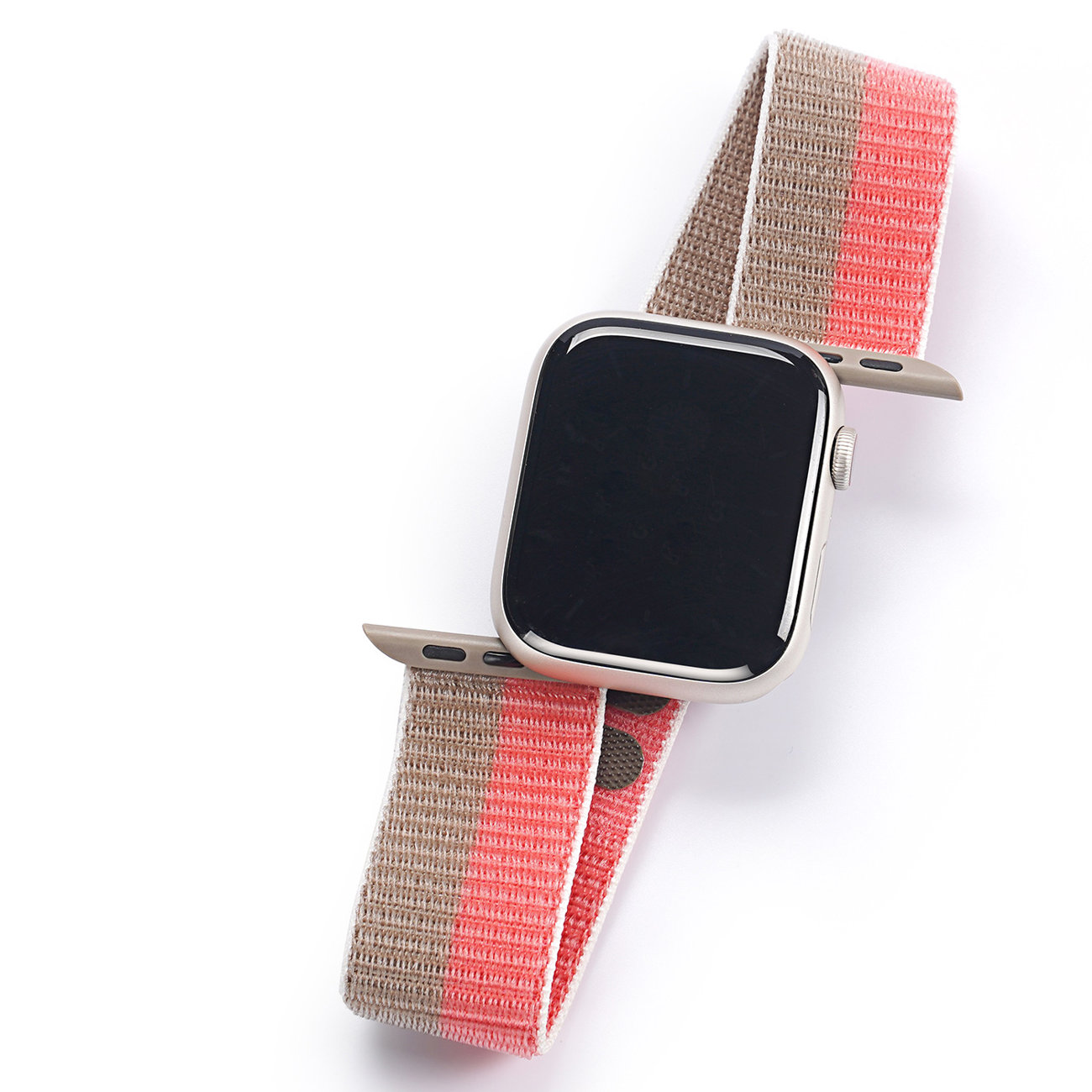 Smartwatch mit beigem Gehäuse und Stoffarmband mit rosa und braunen Streifen auf weißem Grund.