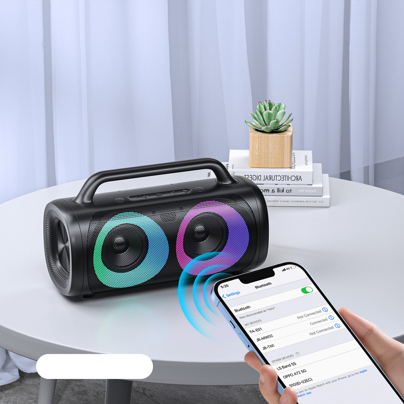 Ein schwarzer Lautsprecher mit bunten Lichtern, verbunden mit einem Smartphone via Bluetooth.