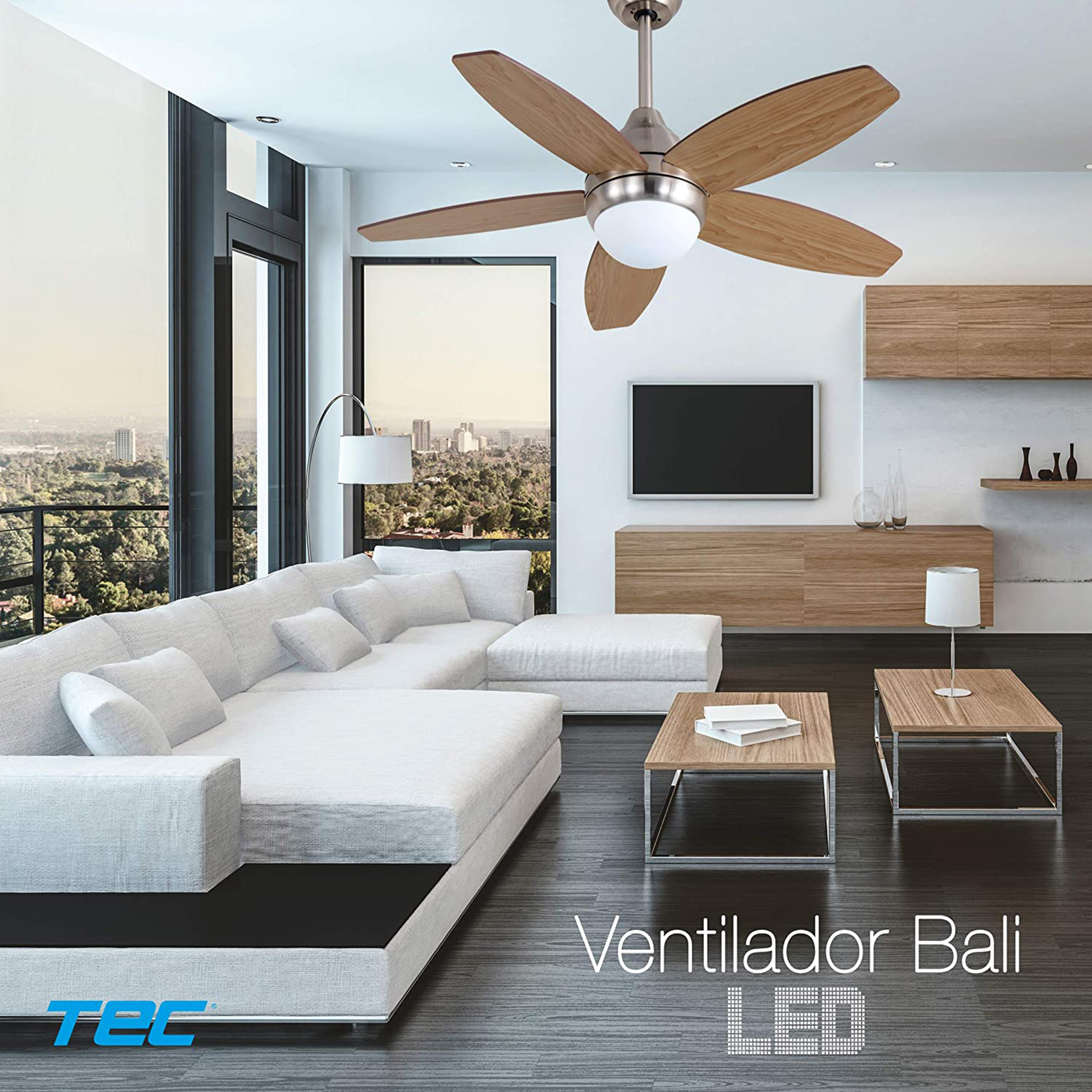 Salón con ventilador de techo, sofá y vista a la ciudad.