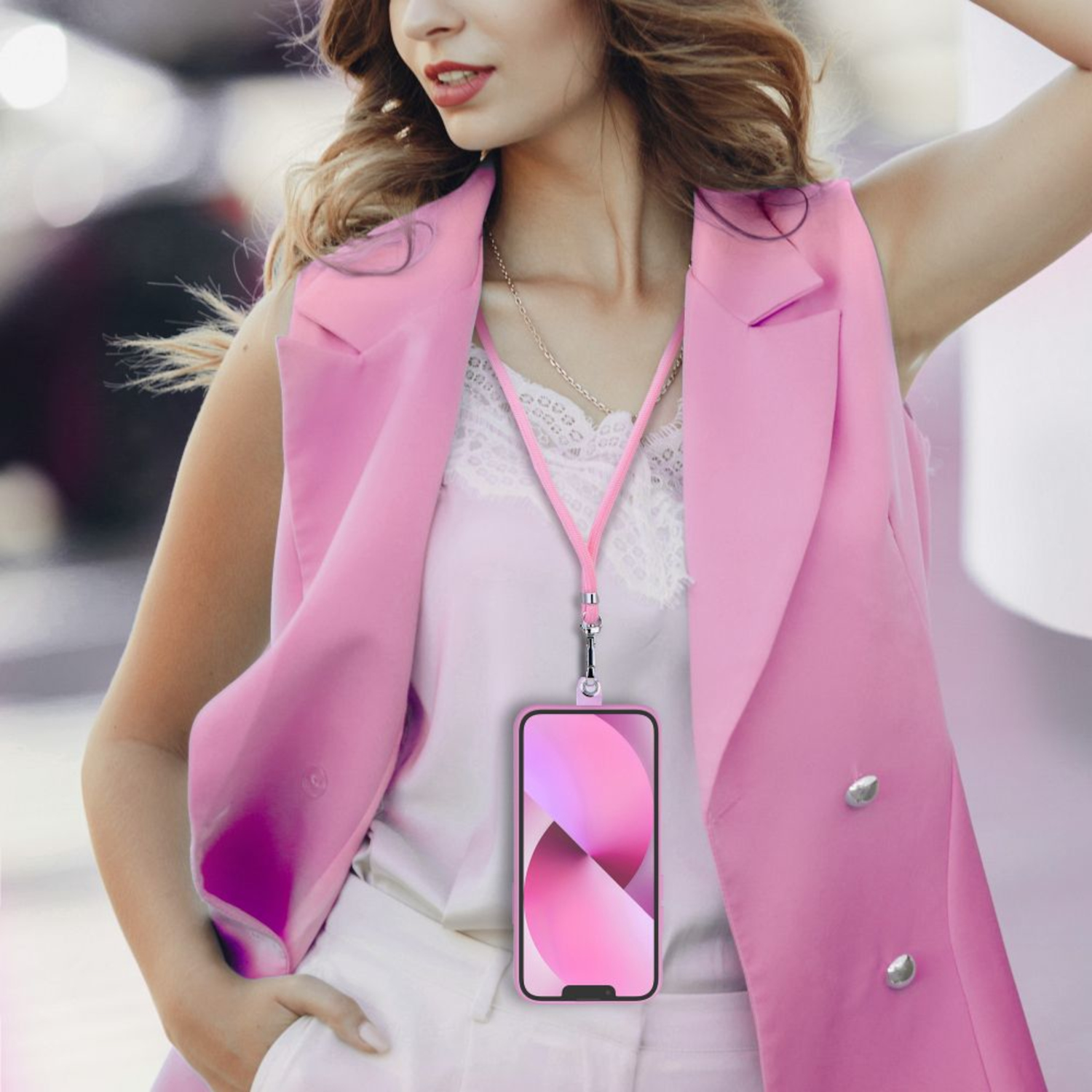 Frau mit rosa Weste, hält ein Telefon mit rosa Hülle und Umhängeband.