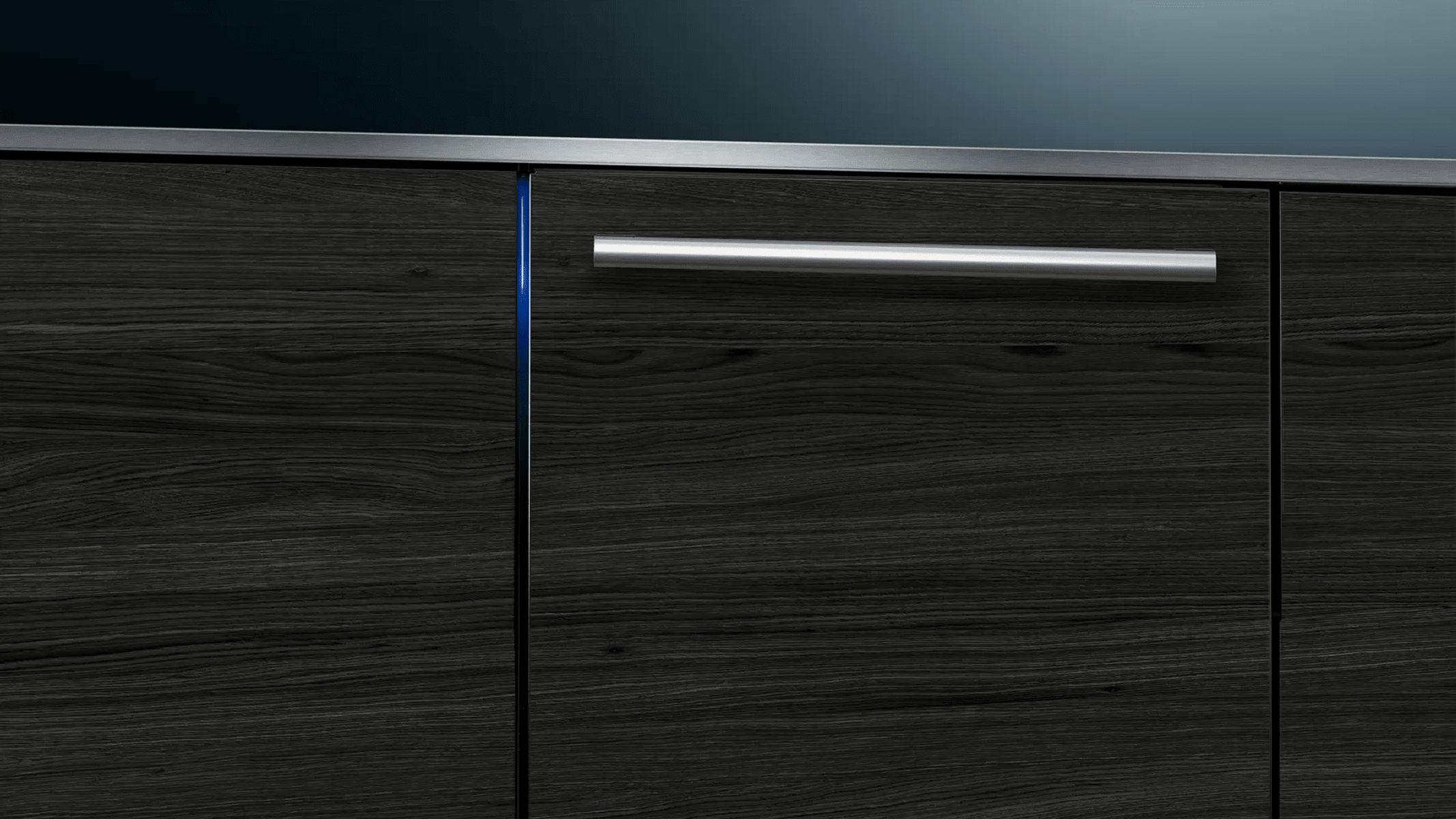 Close-up van een donkere houten kast. Er is een zilveren handgreep en een blauwe lichtstrip.