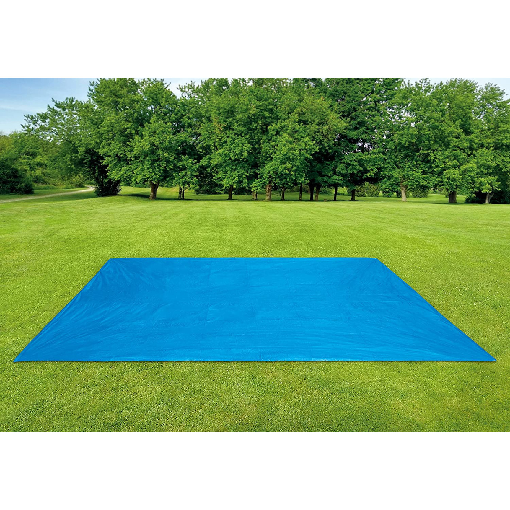 Un telo blu steso su un campo di erba verde, circondato da alberi verdi sullo sfondo.