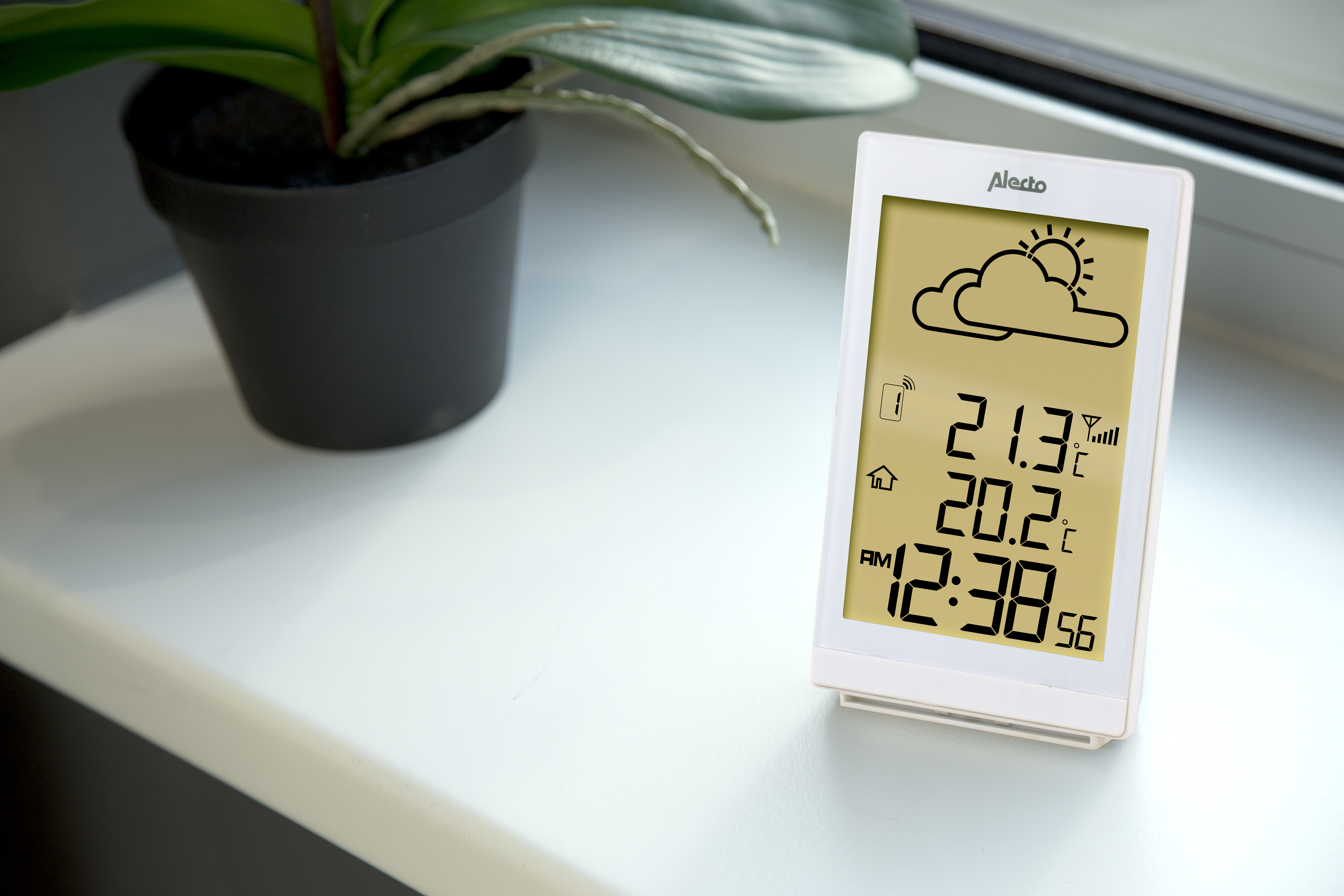 Weiße Wetterstation auf Fensterbank. Zeigt Wetterdaten und Uhrzeit an.
