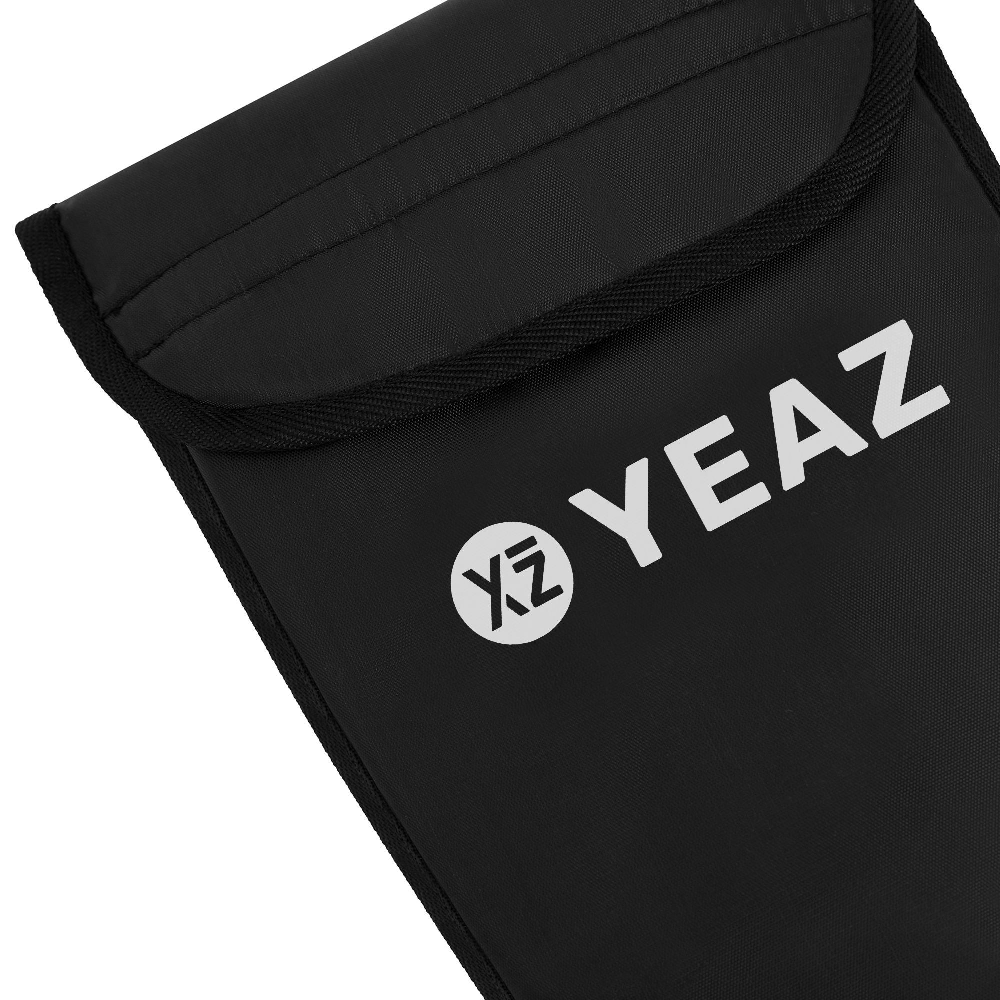 Schwarze Tasche mit weißem "YEAZ"-Logo. Die Tasche hat eine Klappe und eine Naht am Rand.