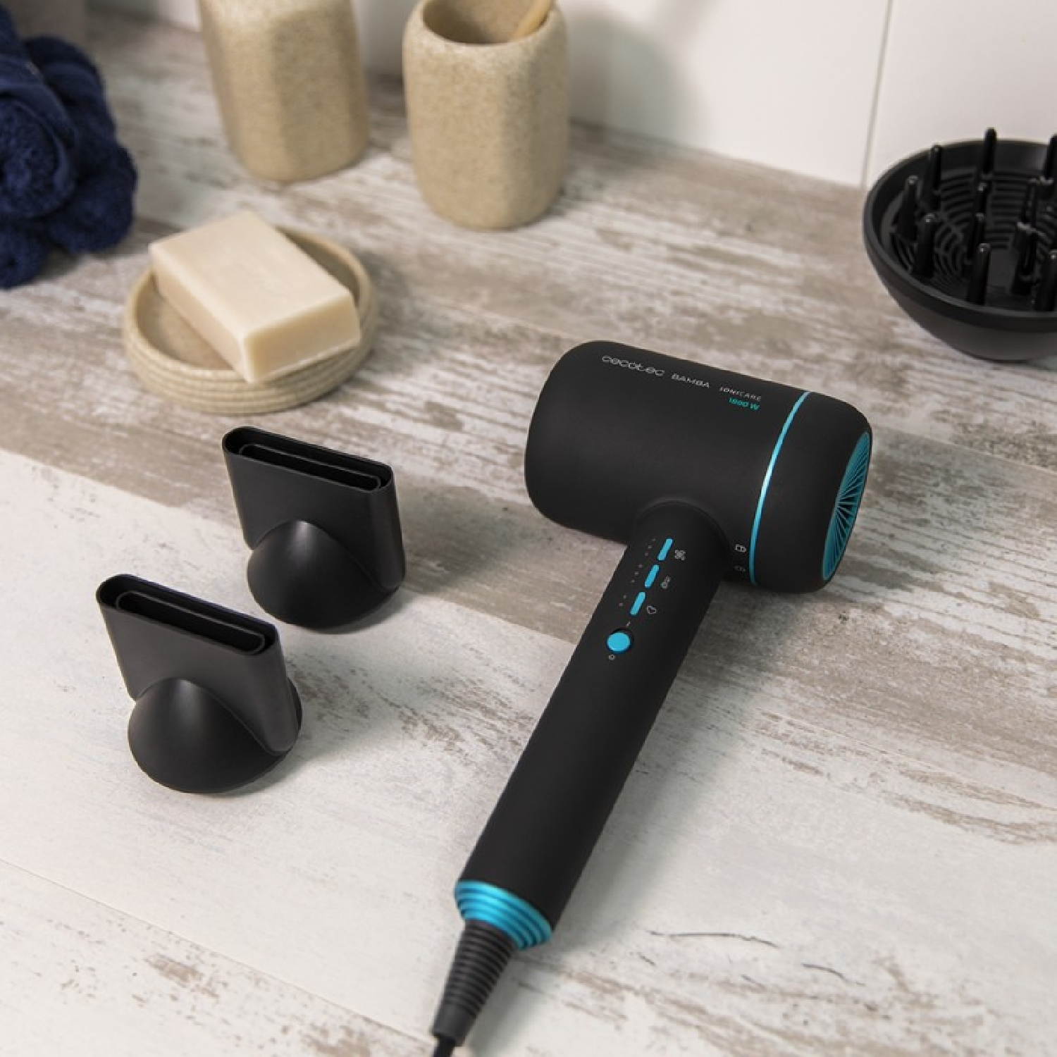 Un asciugacapelli nero e blu con due ugelli e un portasapone su una superficie in legno.