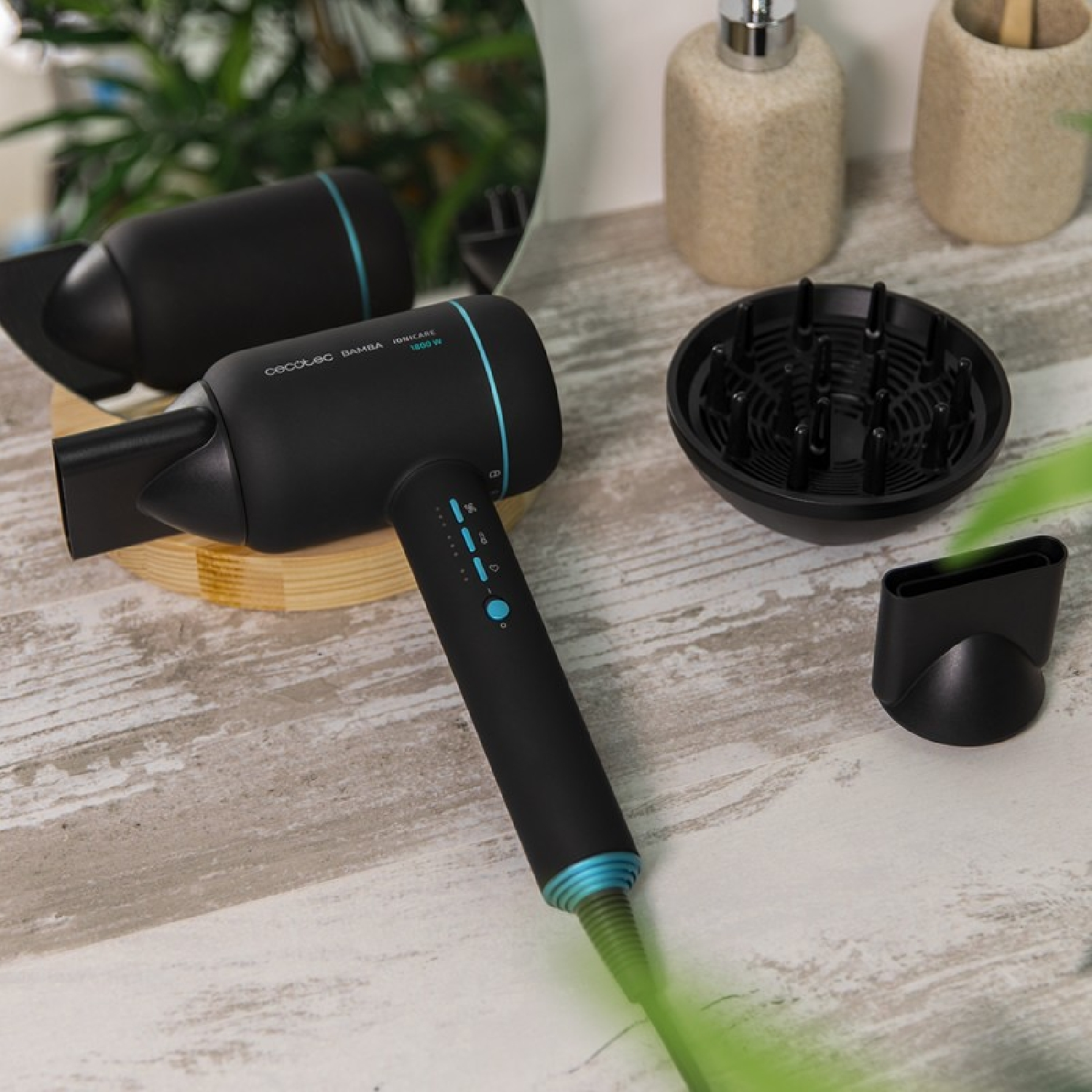 Asciugacapelli nero con accessori su una superficie in legno. Uno specchio e accessori sullo sfondo.