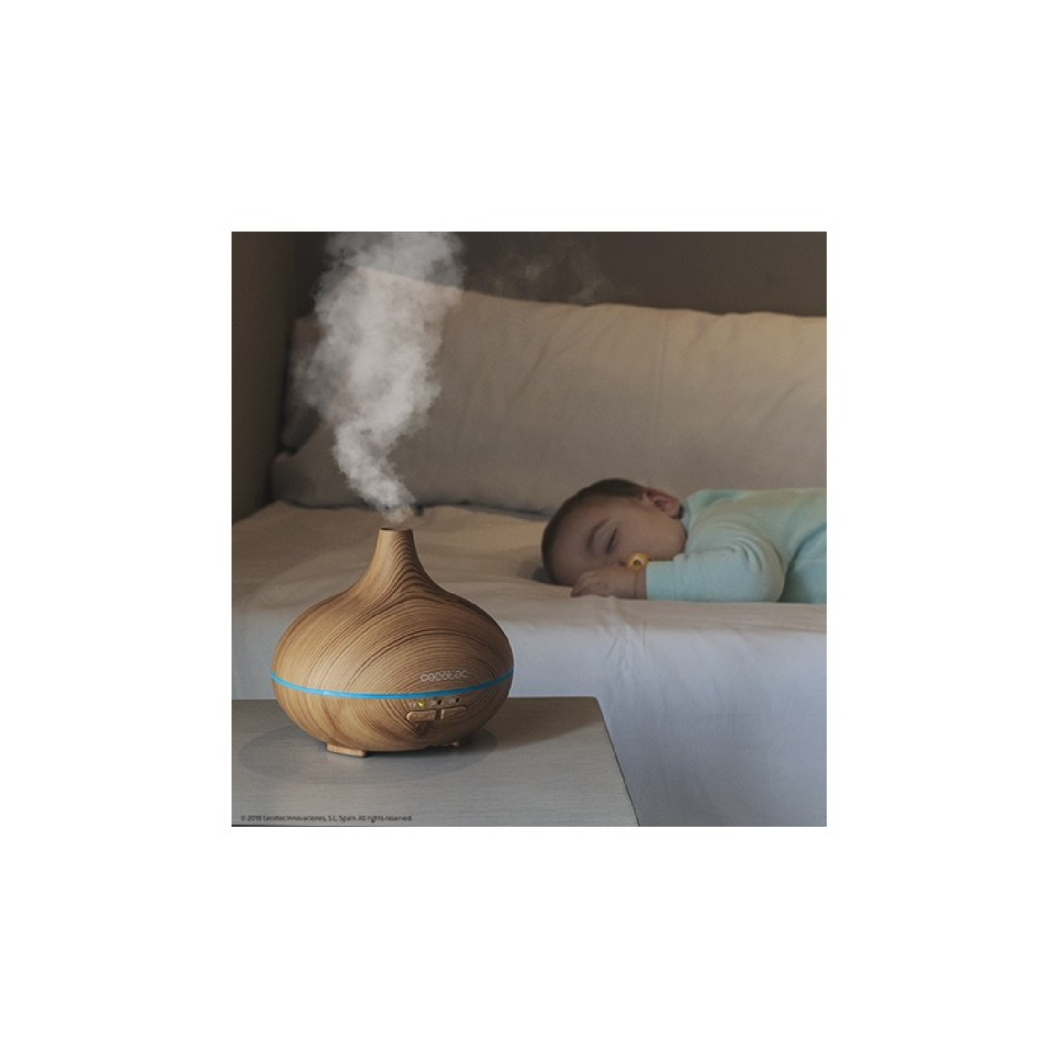 Diffusore di aromi accanto a un bambino che dorme. Diffusore con motivo legno e fascia blu.
