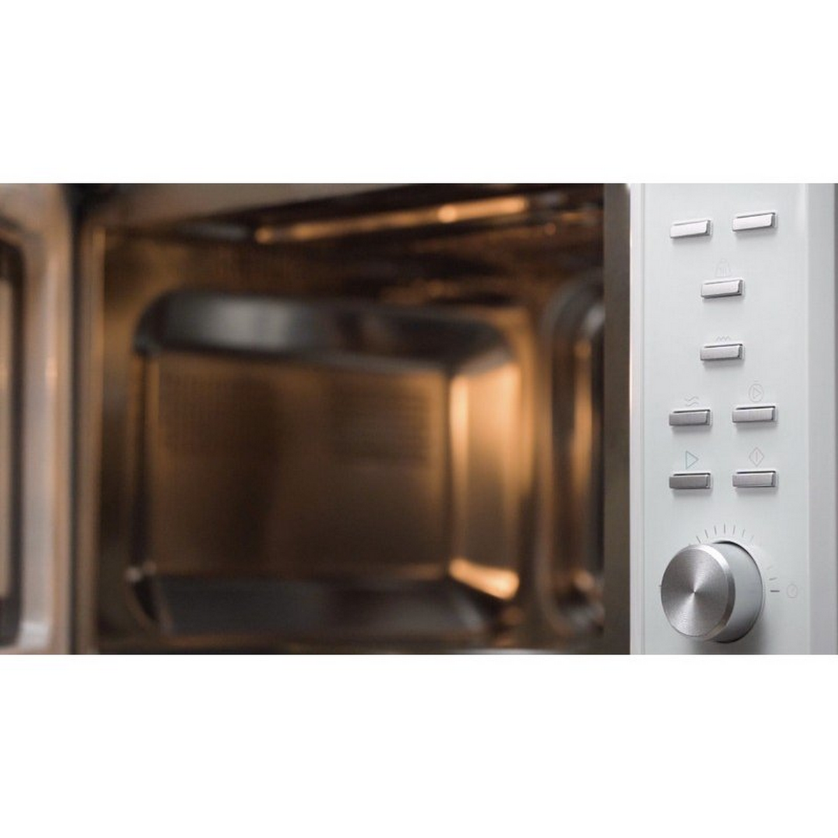 Wnętrze kuchenki mikrofalowej. Widoczny pojemnik na żywność, elementy sterujące po prawej.