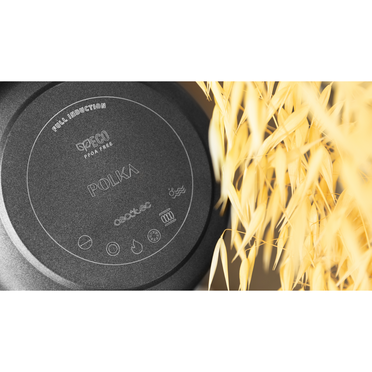 Padella nera con testo POLKA e piante di avena sullo sfondo. La padella ha il testo PFOA FREE.