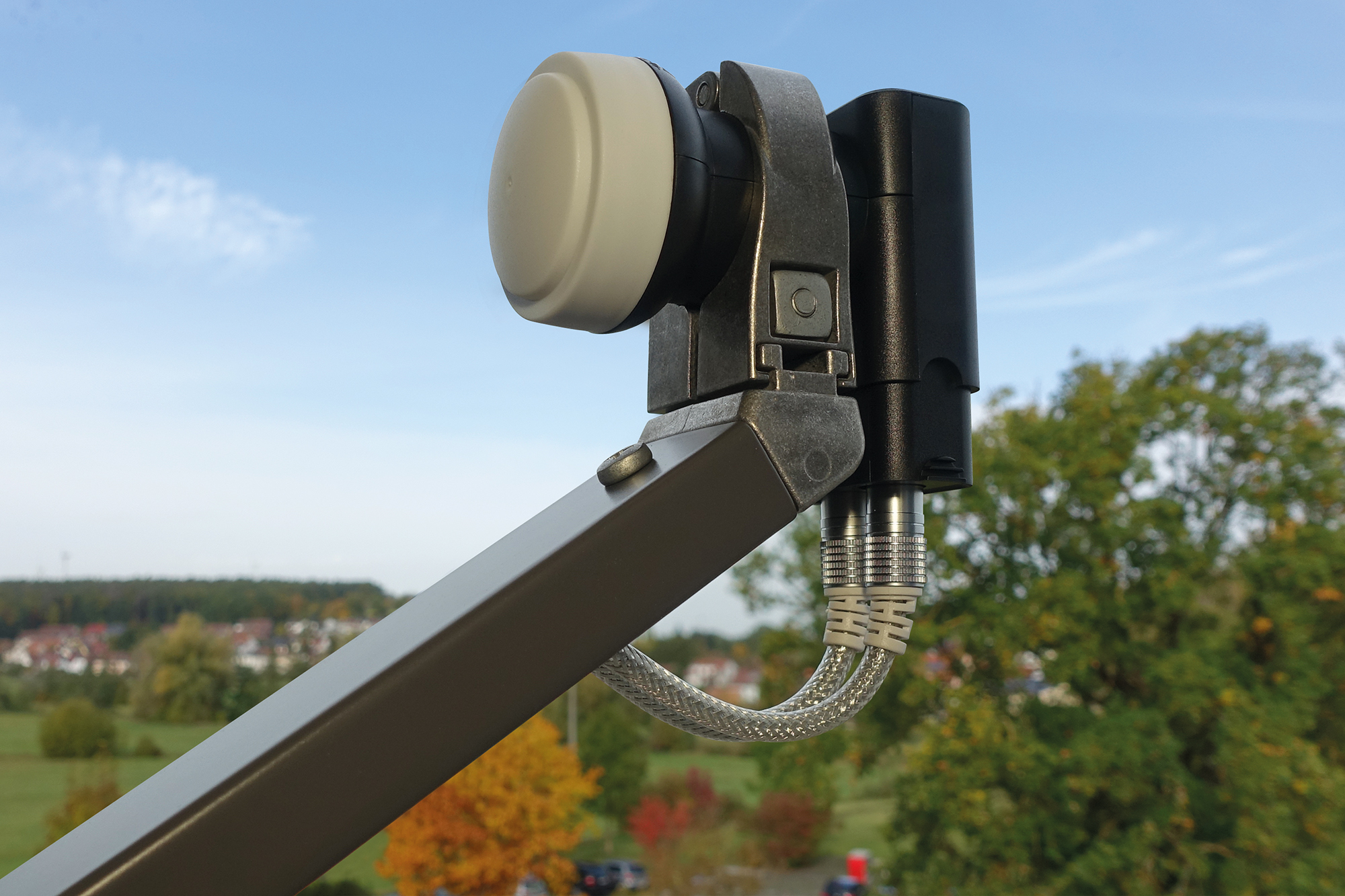 Antena satelitarna zamontowana na zewnątrz z czystym niebem i drzewami.