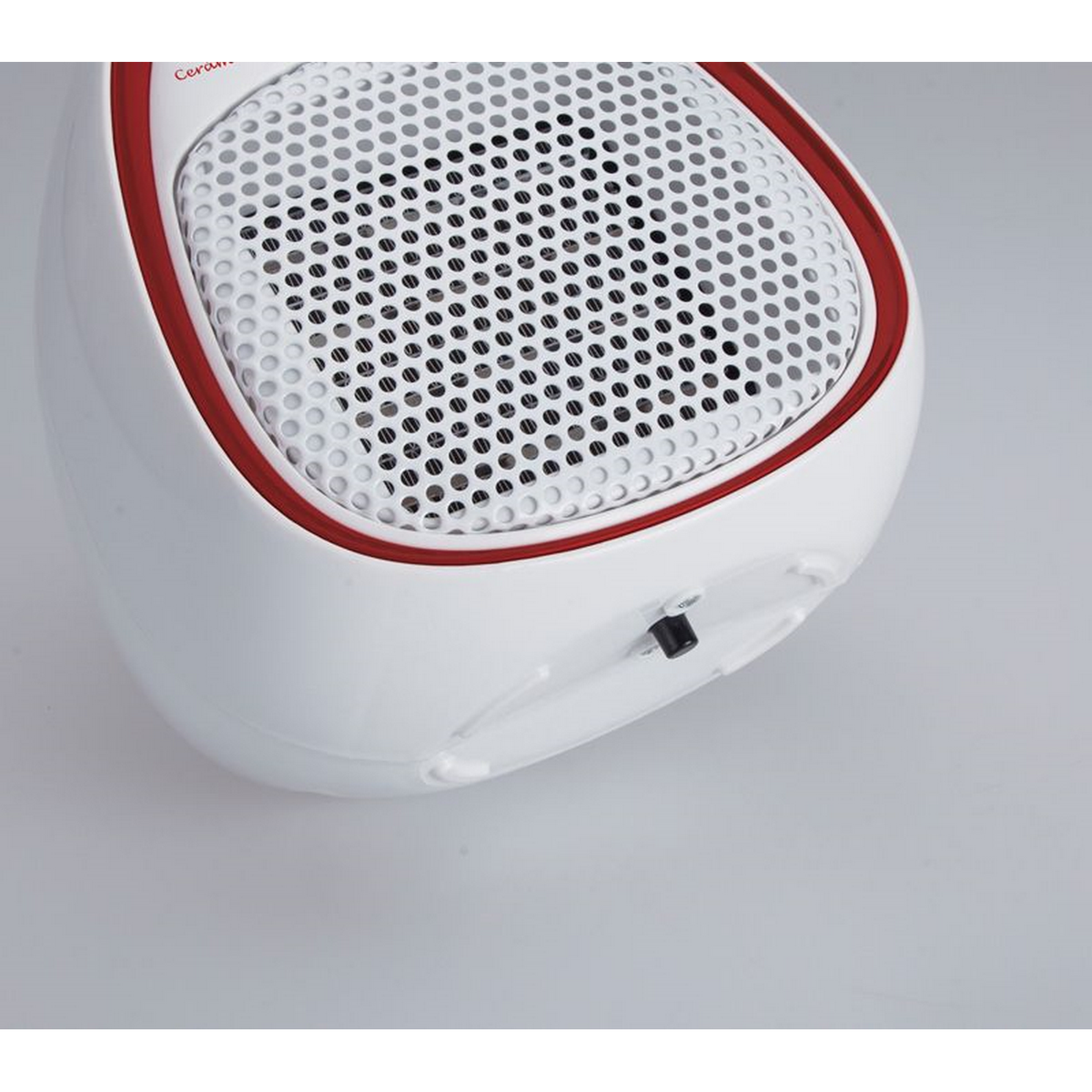 Biało-czerwony grzejnik elektryczny na białej powierzchni. Ujęcie z bliska.