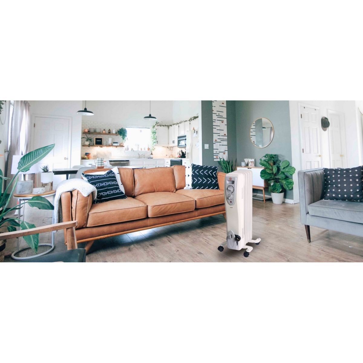 Una sala de estar con un sofá, un radiador y otros muebles, con una cocina blanca al fondo.