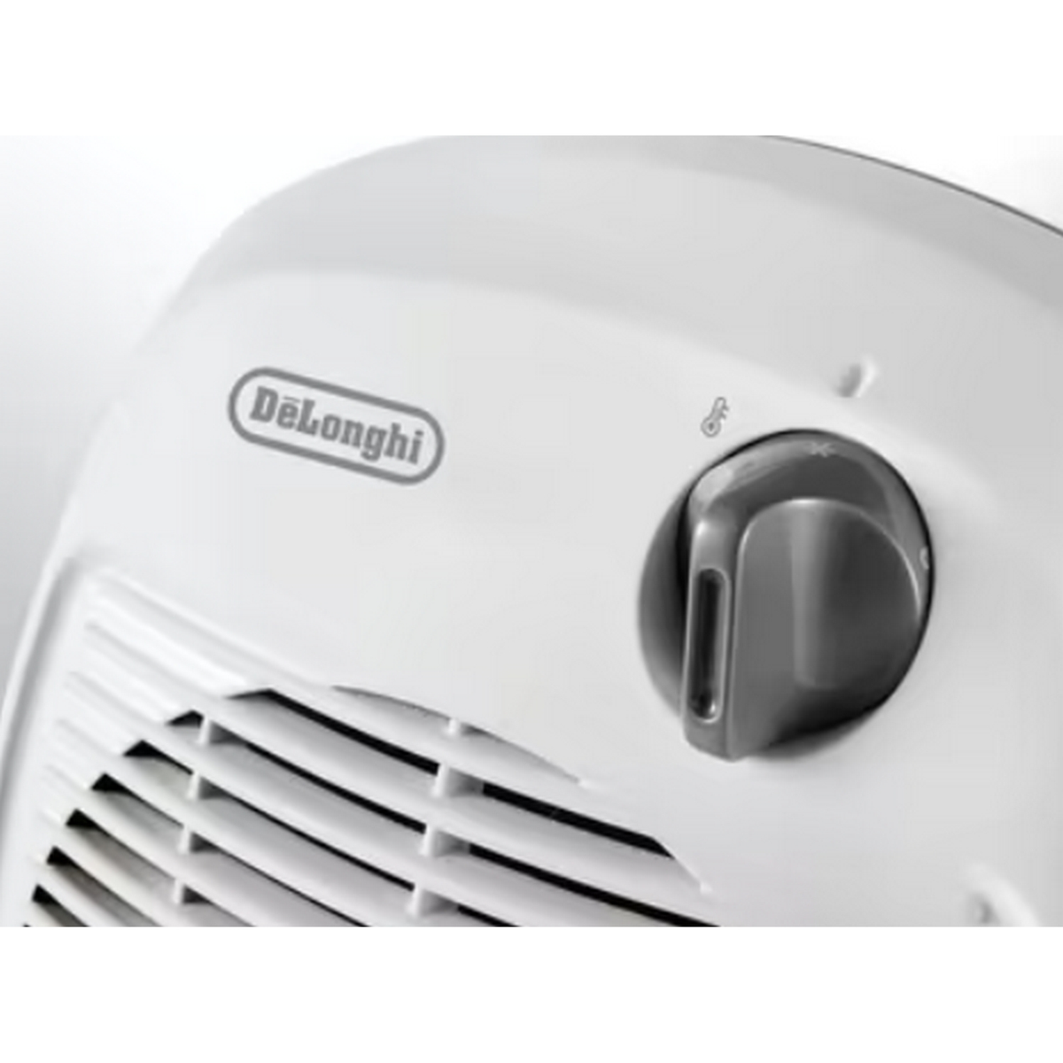 Primer plano del panel de control de un calefactor Delonghi blanco. Un dial para ajustar la temperatura. Fondo blanco.