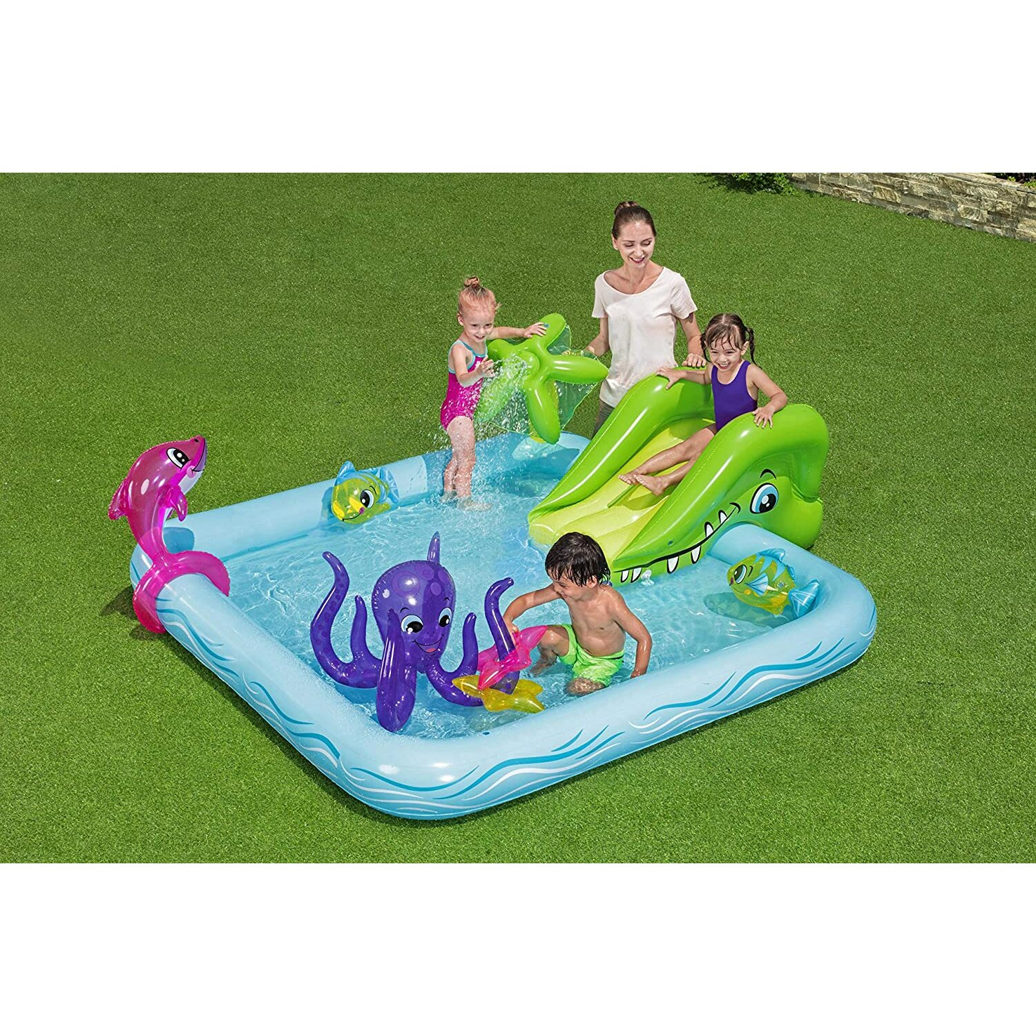 Kinder spielen in einem blauen Pool. Ein Oktopus, ein Delfin und eine Rutsche.