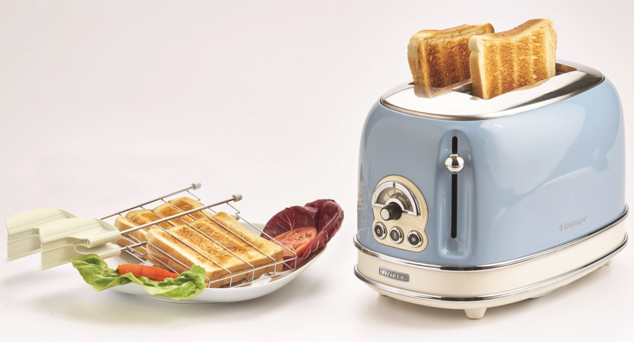 Niebiesko-kremowy toster z tostami. Stojak trzyma tosty, pomidory i sałatę.