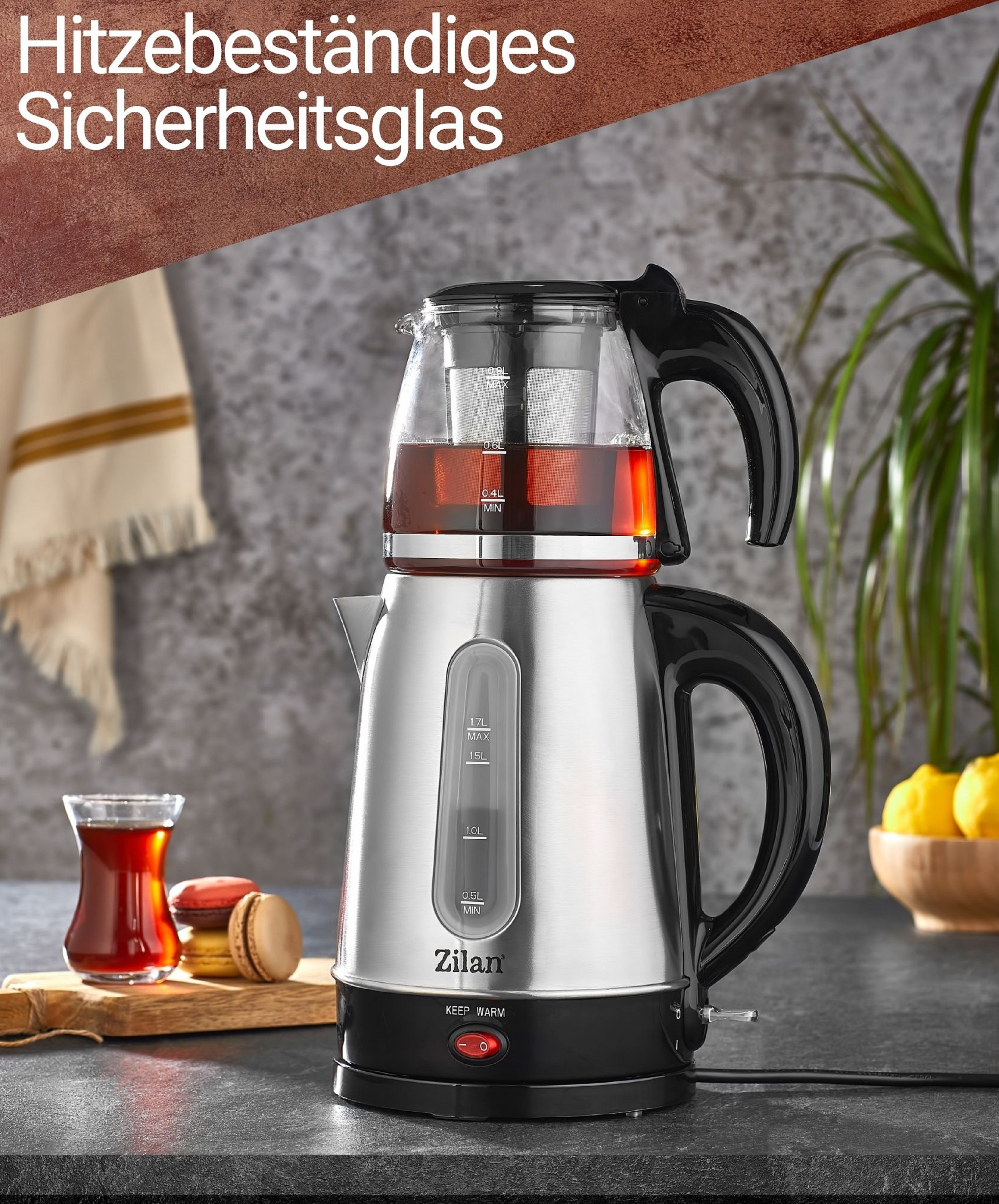 Ein silberner und schwarzer elektrischer Teekessel mit Glasaufsatz und schwarzem Griff, mit Tee.