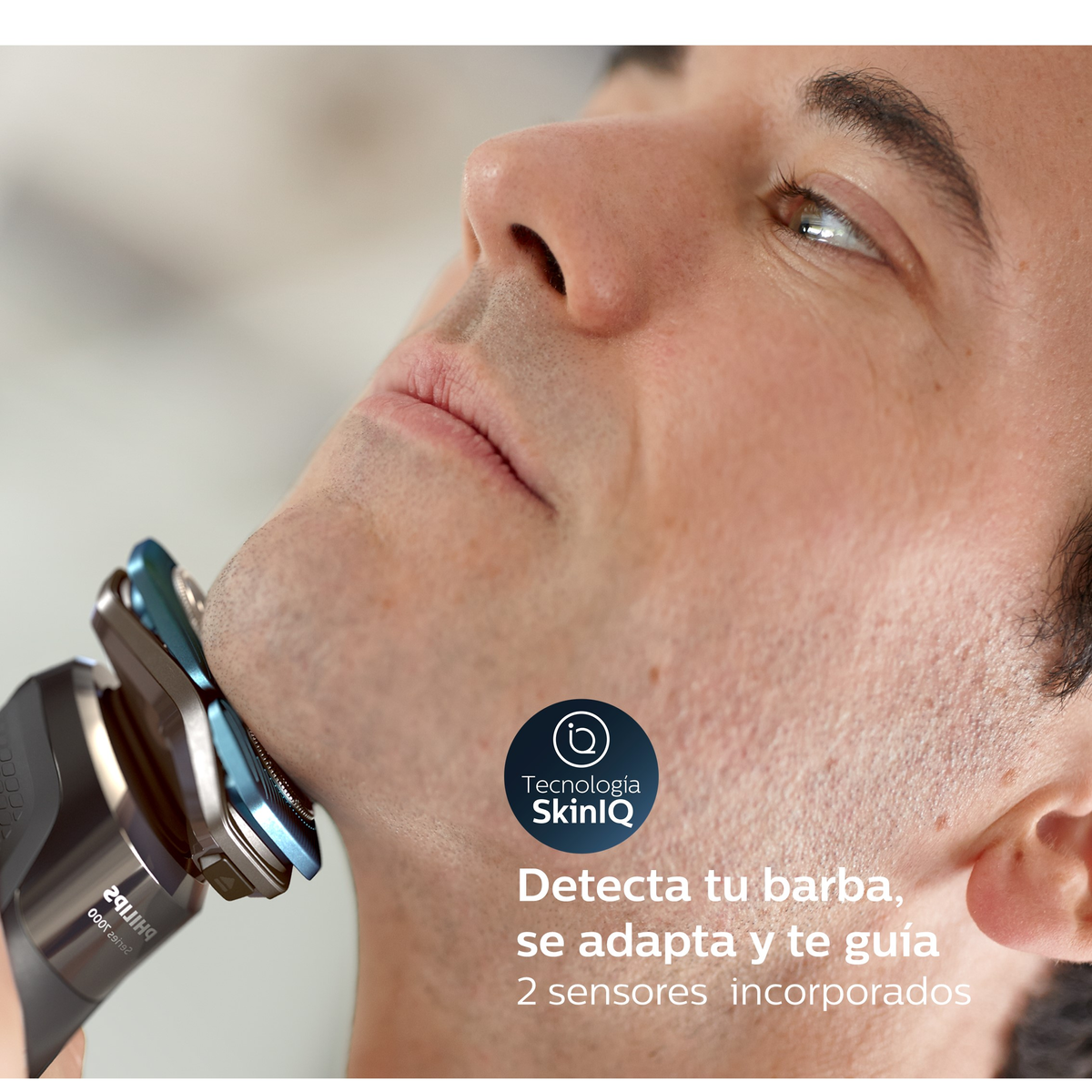 Un hombre se afeita con una afeitadora eléctrica Philips. La afeitadora está cerca de su cara.