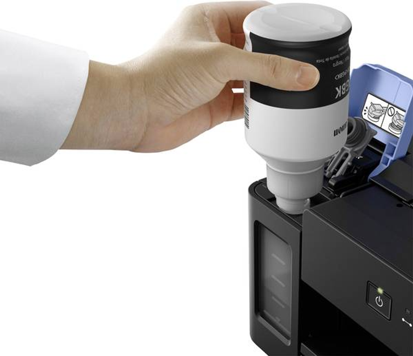 Ręka napełniająca zbiornik z tuszem drukarki czarnym pojemnikiem z tuszem.