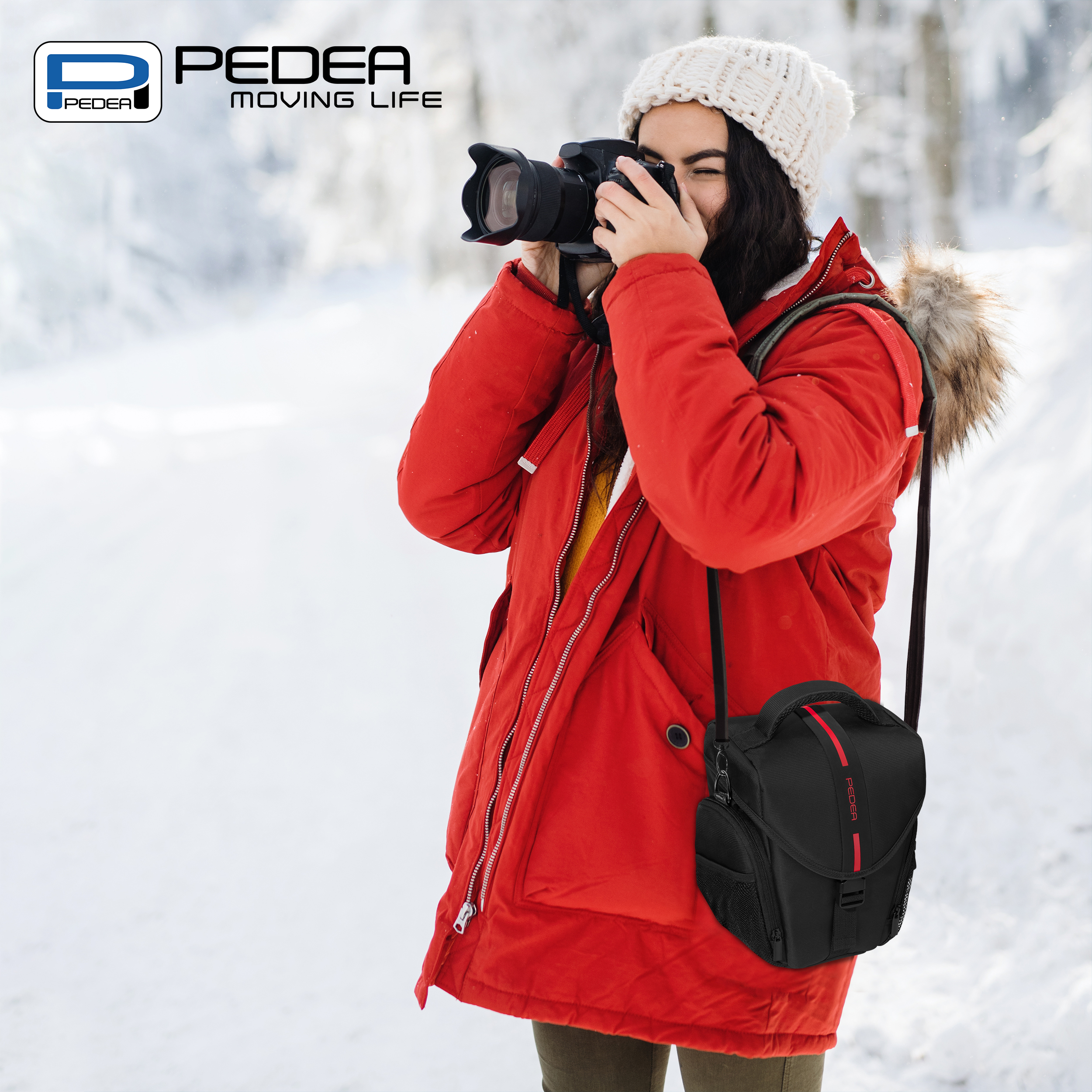 Frau in roter Jacke, die in einem verschneiten Wald Fotos macht, mit einer Kameratasche.