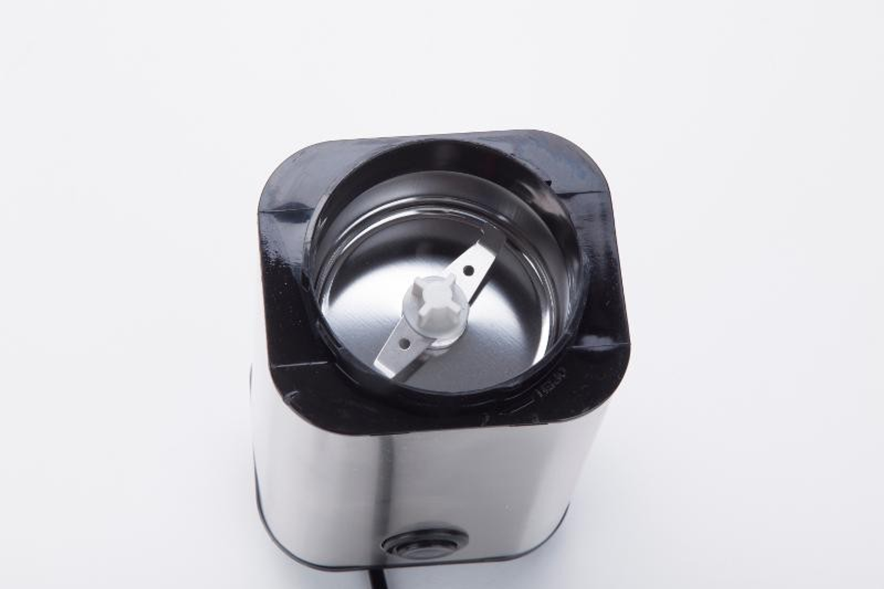 Eine Kaffeemühle mit offenem Deckel. Die Klinge und das Innere sind sichtbar.