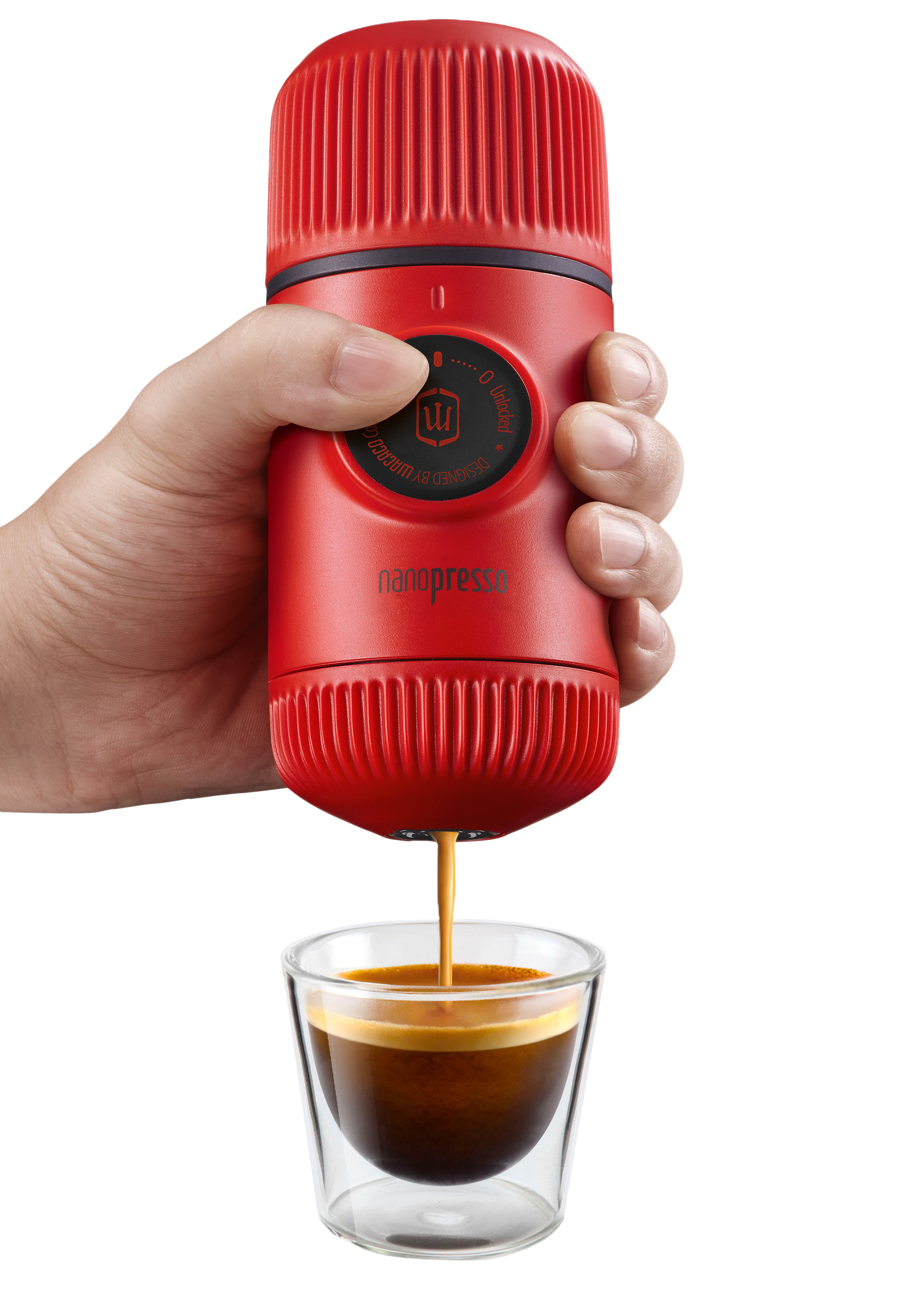 Eine rote tragbare Espressomaschine gibt Kaffee in ein klares Glas aus, das von einer Hand gehalten wird.
