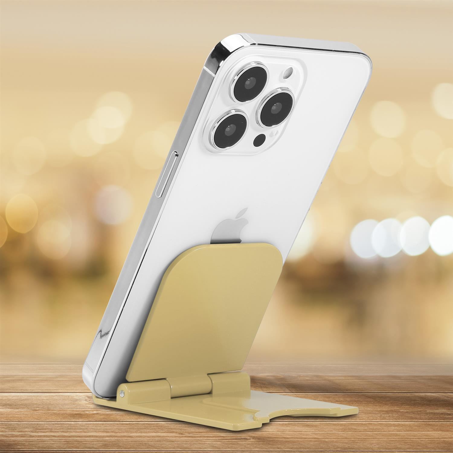 Weißes Telefon mit Kamerabuckel. Es steht auf einem beigen Ständer auf einer Holzoberfläche.