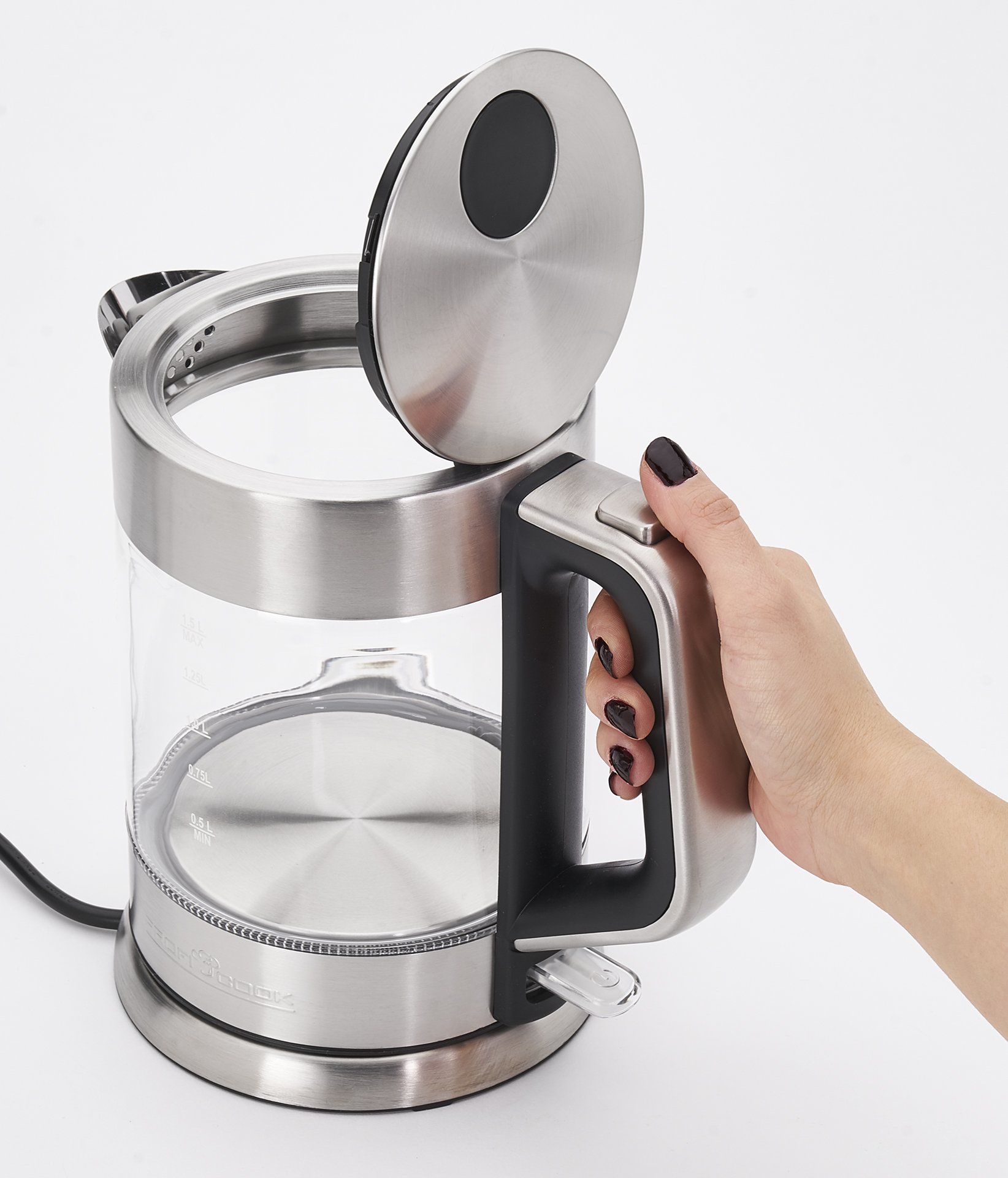 Przezroczysty szklany czajnik elektryczny z otwartą pokrywą, trzymany przez dłoń, pokazujący wnętrze.