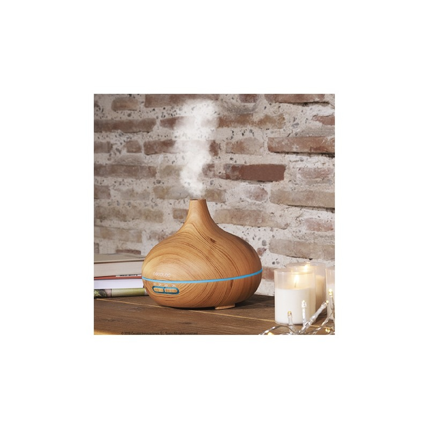 Diffusore in legno con vapore che emana, candele e libri su un tavolo di legno.