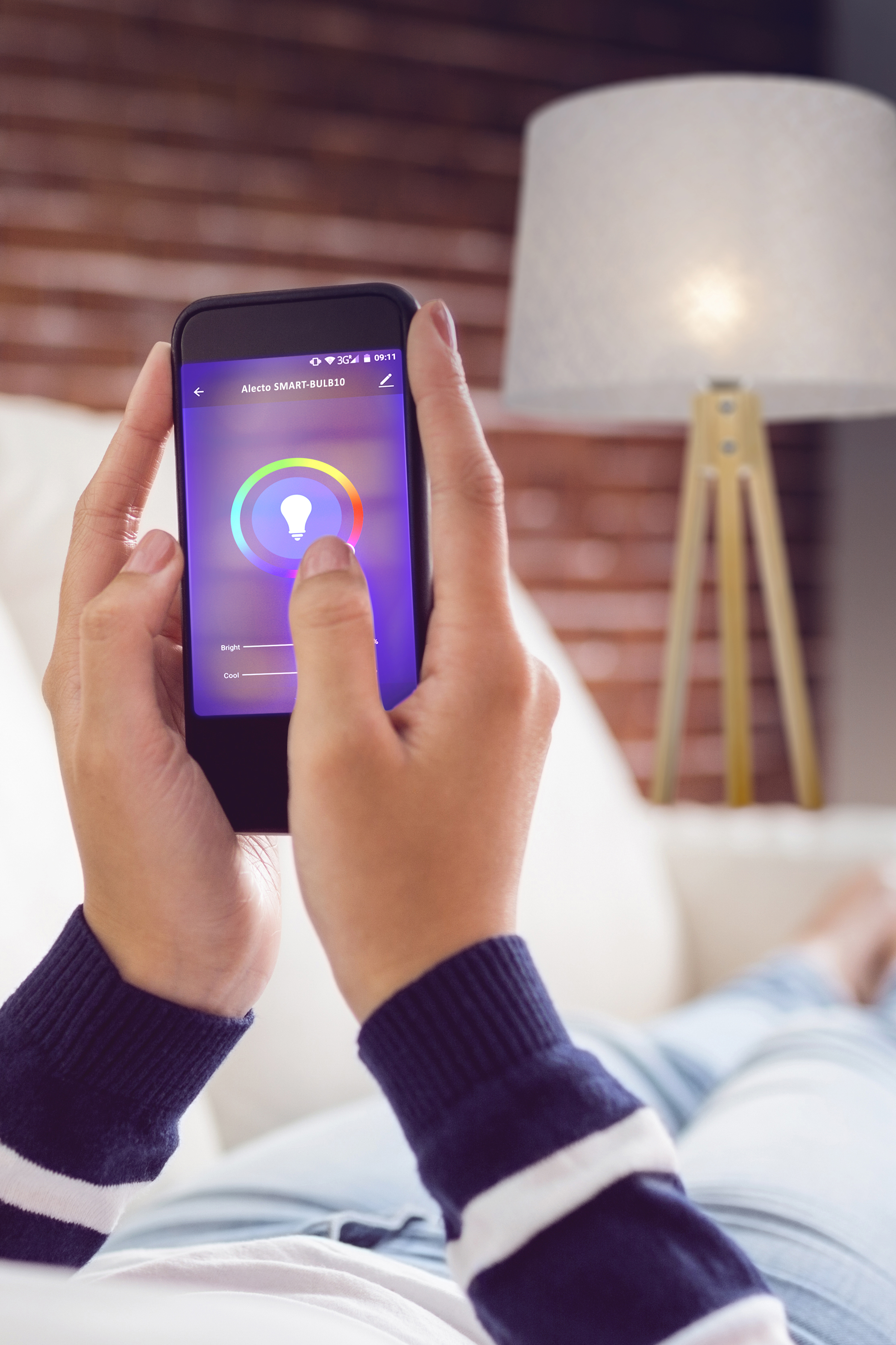 Hände halten ein Telefon zur Steuerung einer Smart-Lampe. Das Telefon zeigt eine Farbrad-Oberfläche.