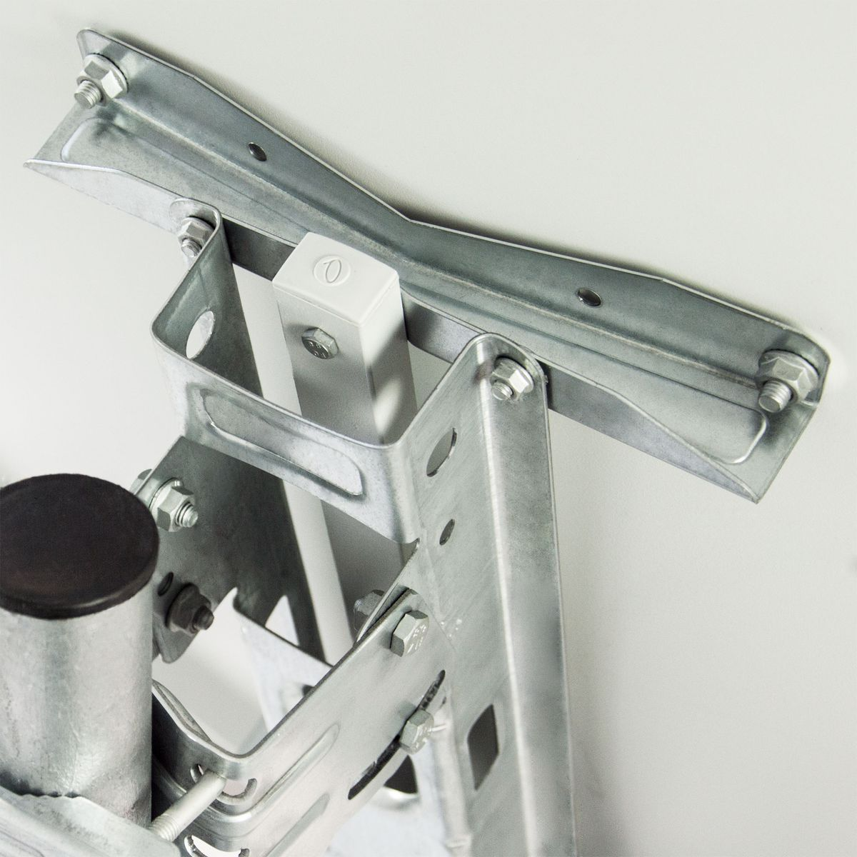 Metallhalterung auf weißer Oberfläche, mit Schrauben und einem weißen Kunststoffelement.