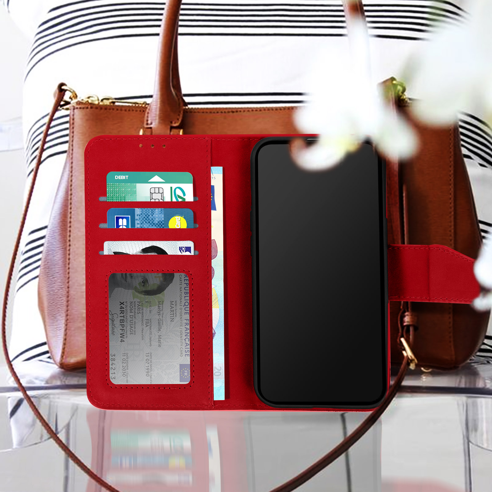Étui de téléphone rouge avec cartes et téléphone. Femme en chemise rayée et sac à main en arrière-plan.