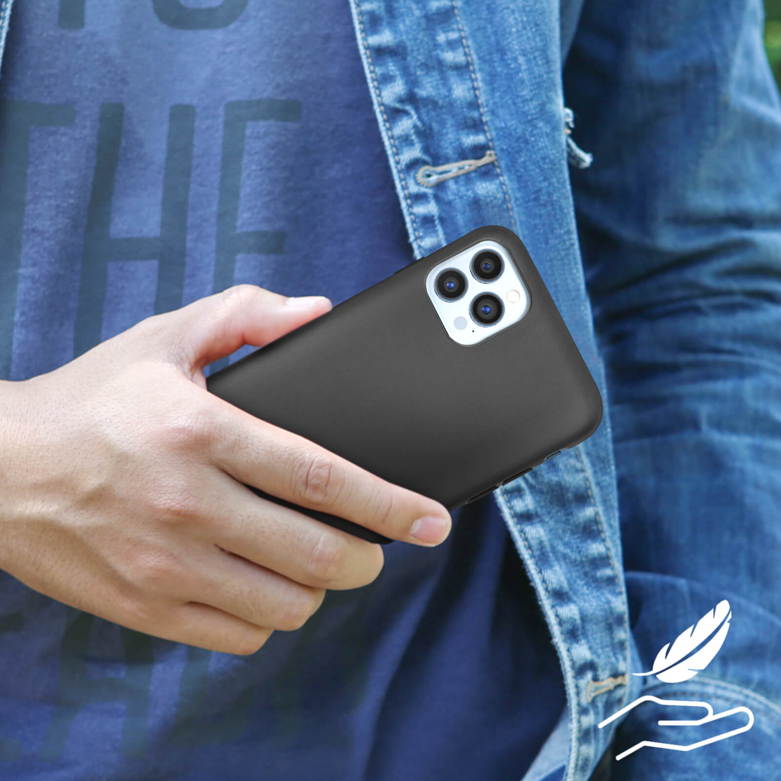 Una persona tiene in mano un telefono nero in una giacca di jeans. Il telefono ha più lenti.