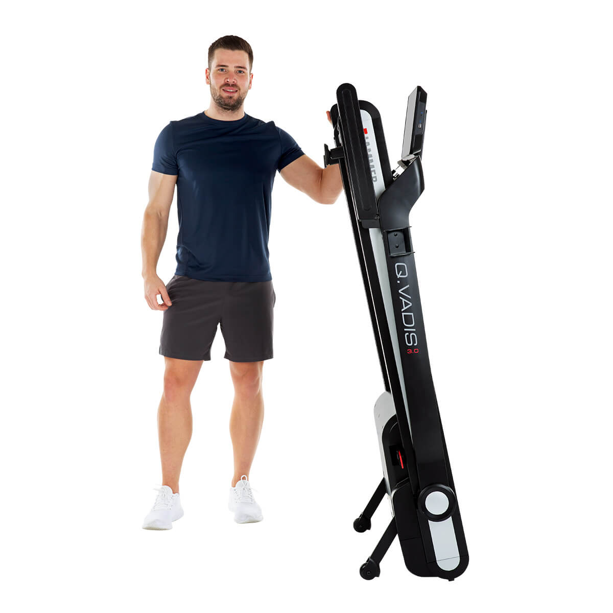 Mann steht neben einem zusammengeklappten Laufband. Er lächelt, trägt Shorts und T-Shirt.