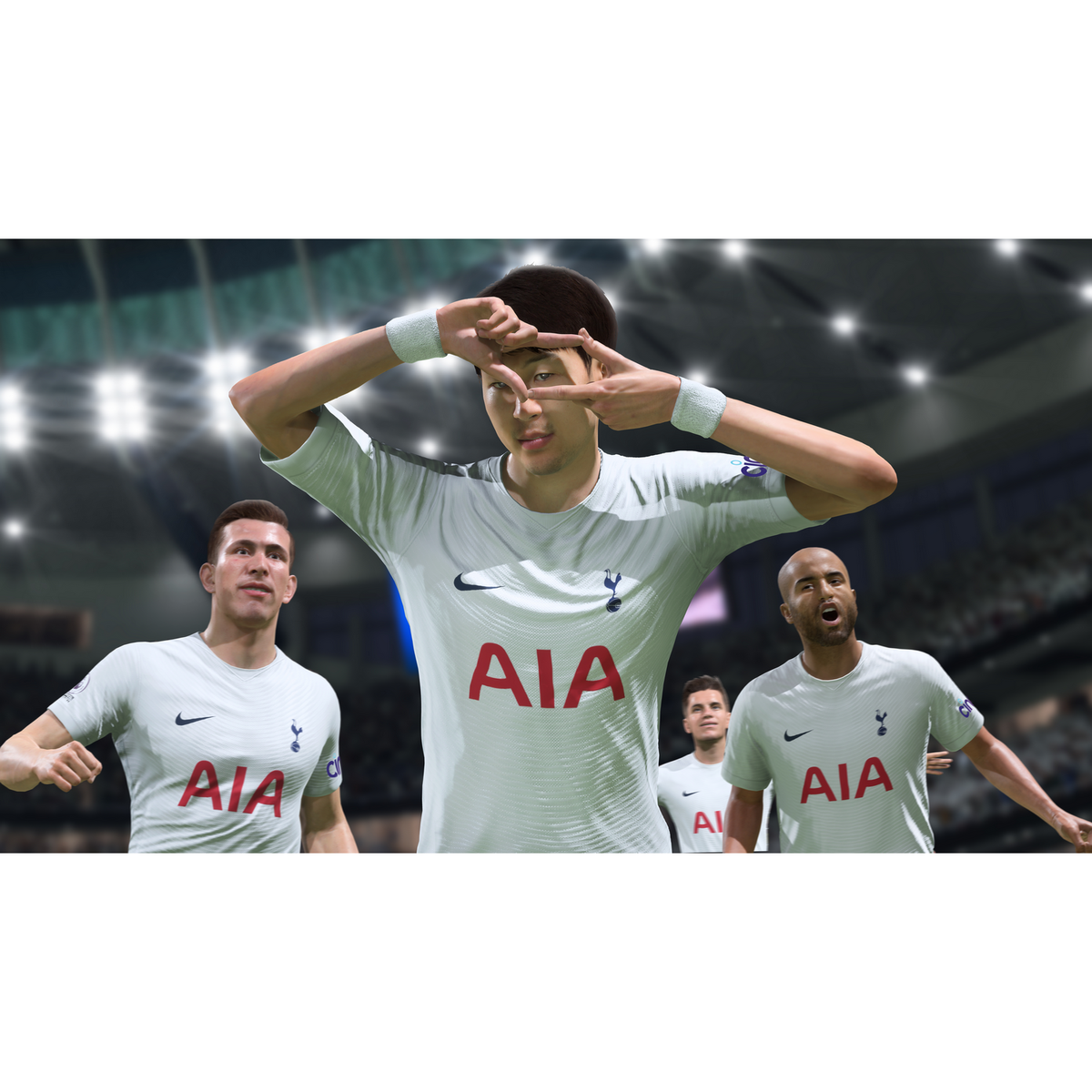 Jugadores de fútbol con camisetas blancas celebran con las manos formando un corazón.