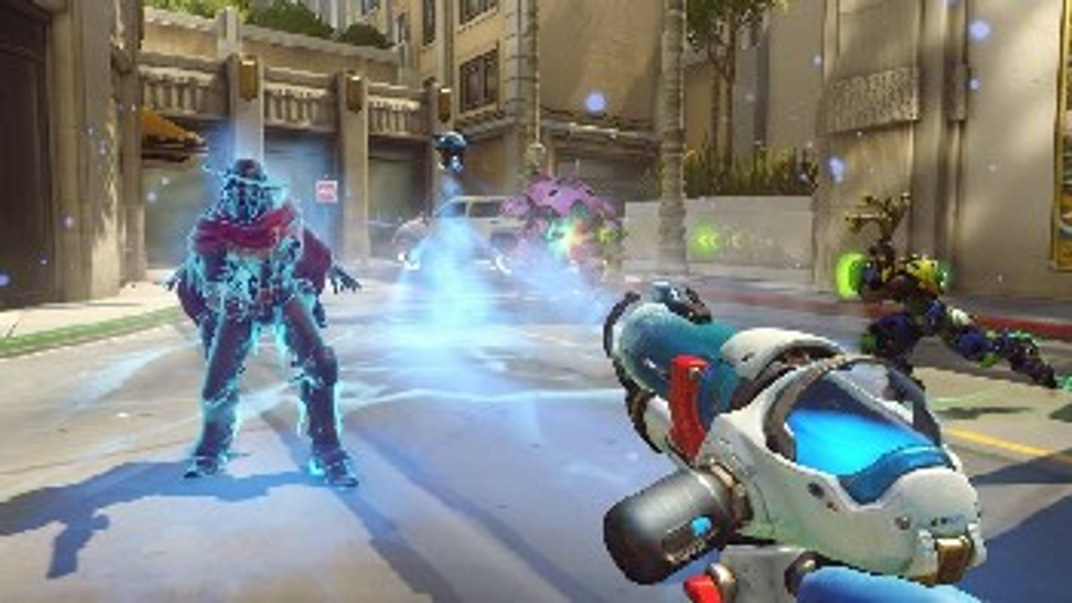 Scena z gry Overwatch. Futurystyczne postacie walczą na ulicy miasta.