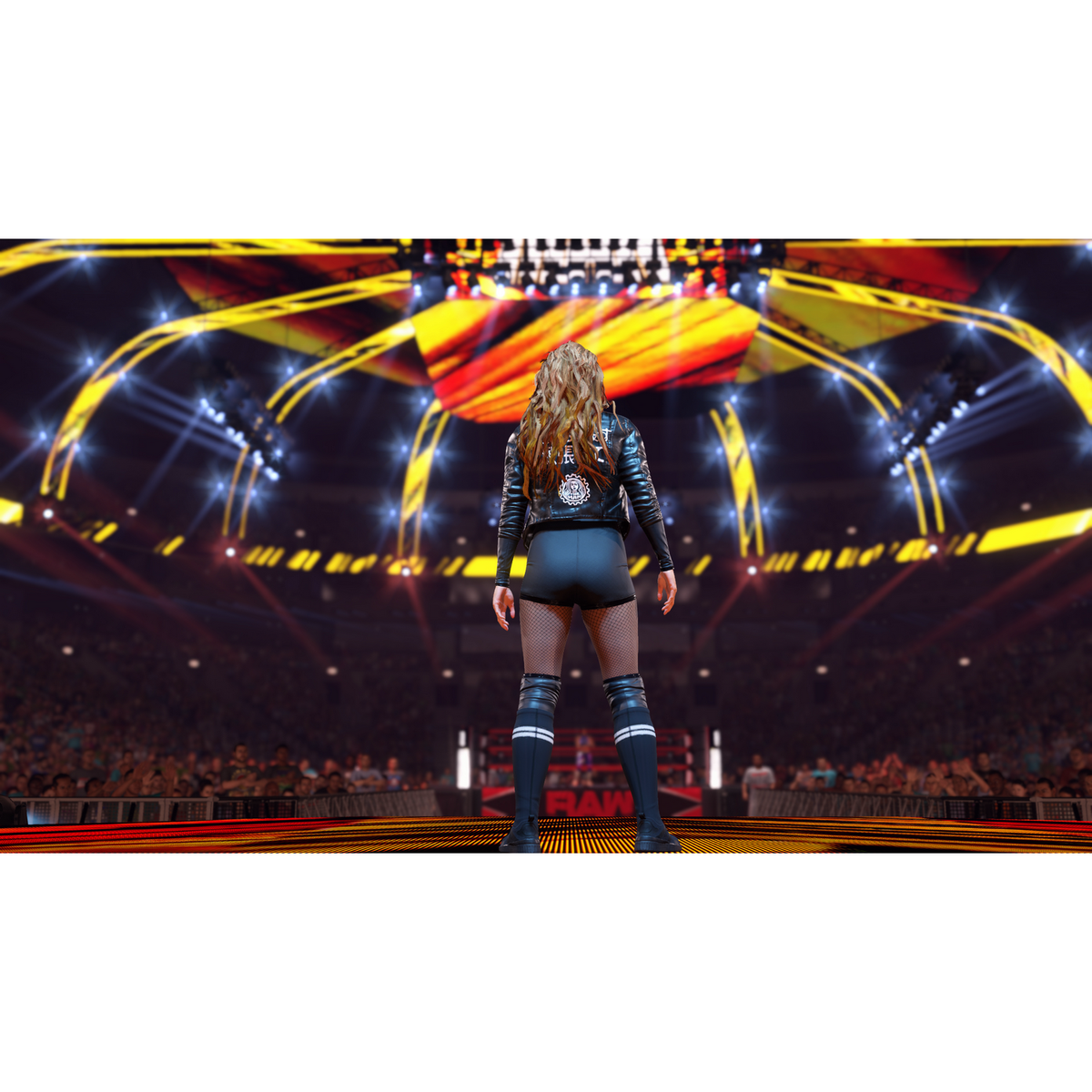 Escena del juego WWE 2K23. Una mujer de cuero negro está en un ring de lucha libre, mirando a la multitud.