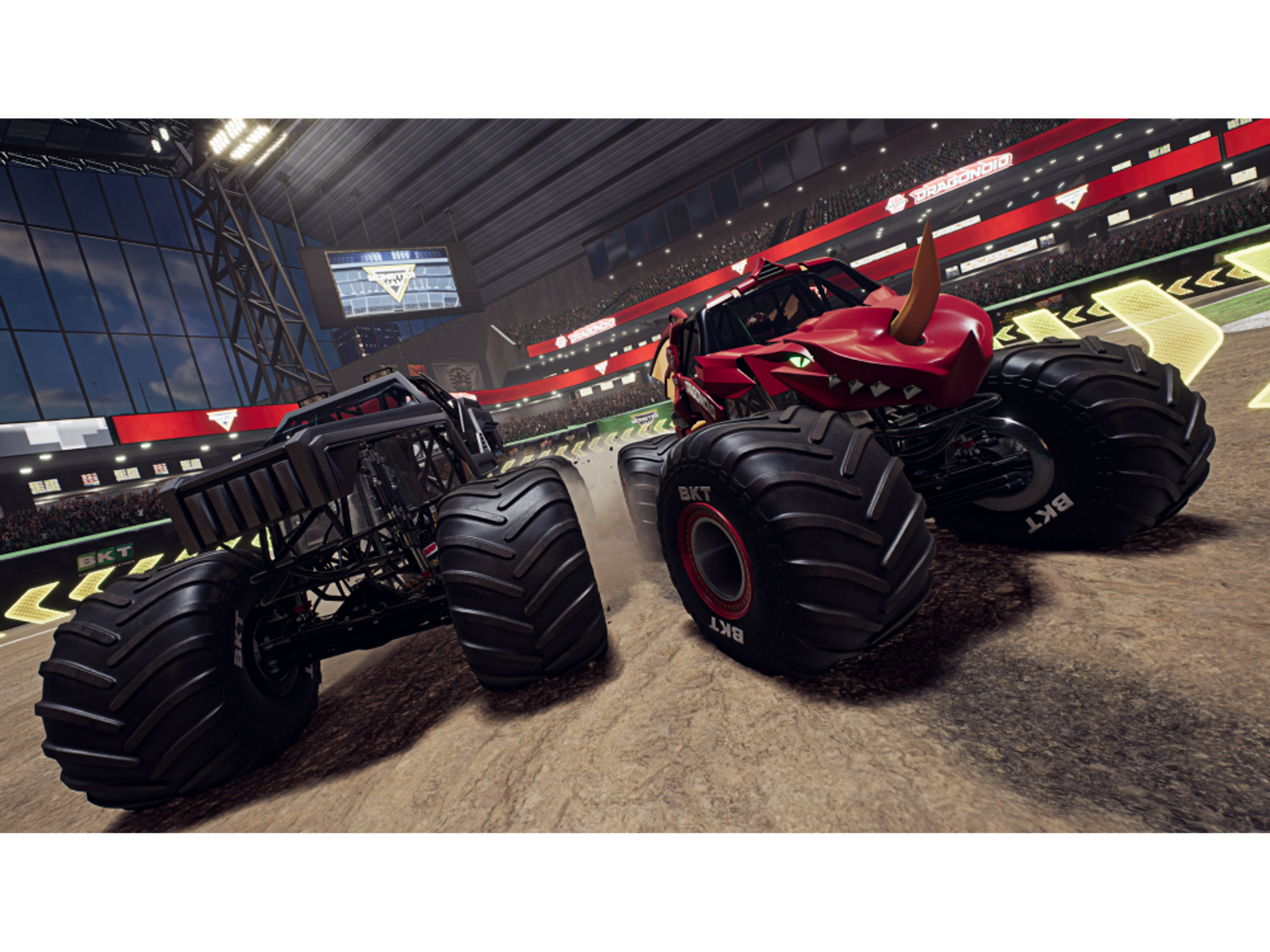 Monster trucki na stadionie. Jeden jest czerwony z rogami, a drugi czarny. Widoczne są loga BKT.