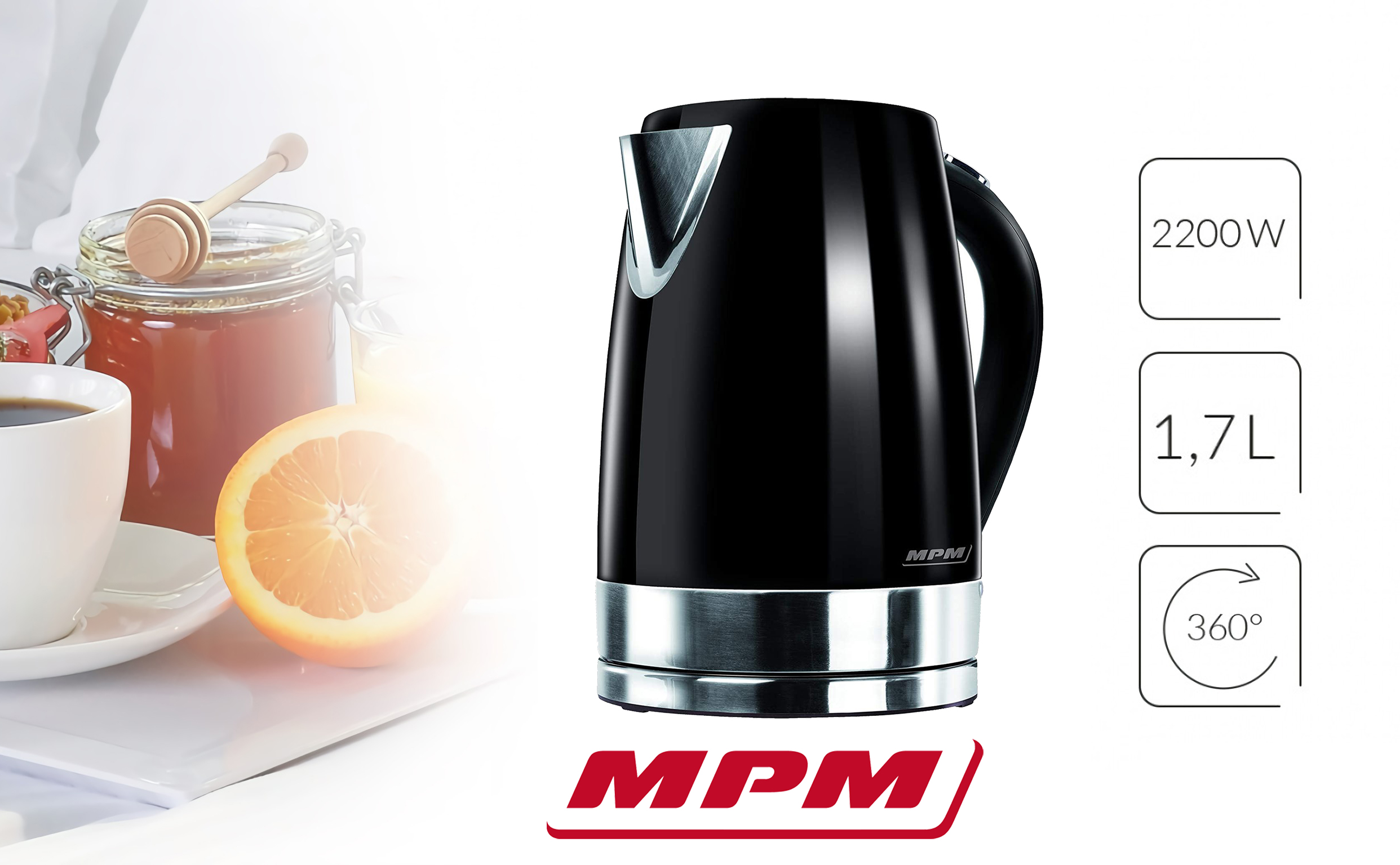 Hervidor eléctrico negro con detalles plateados. Está sobre una superficie blanca con una naranja y café.