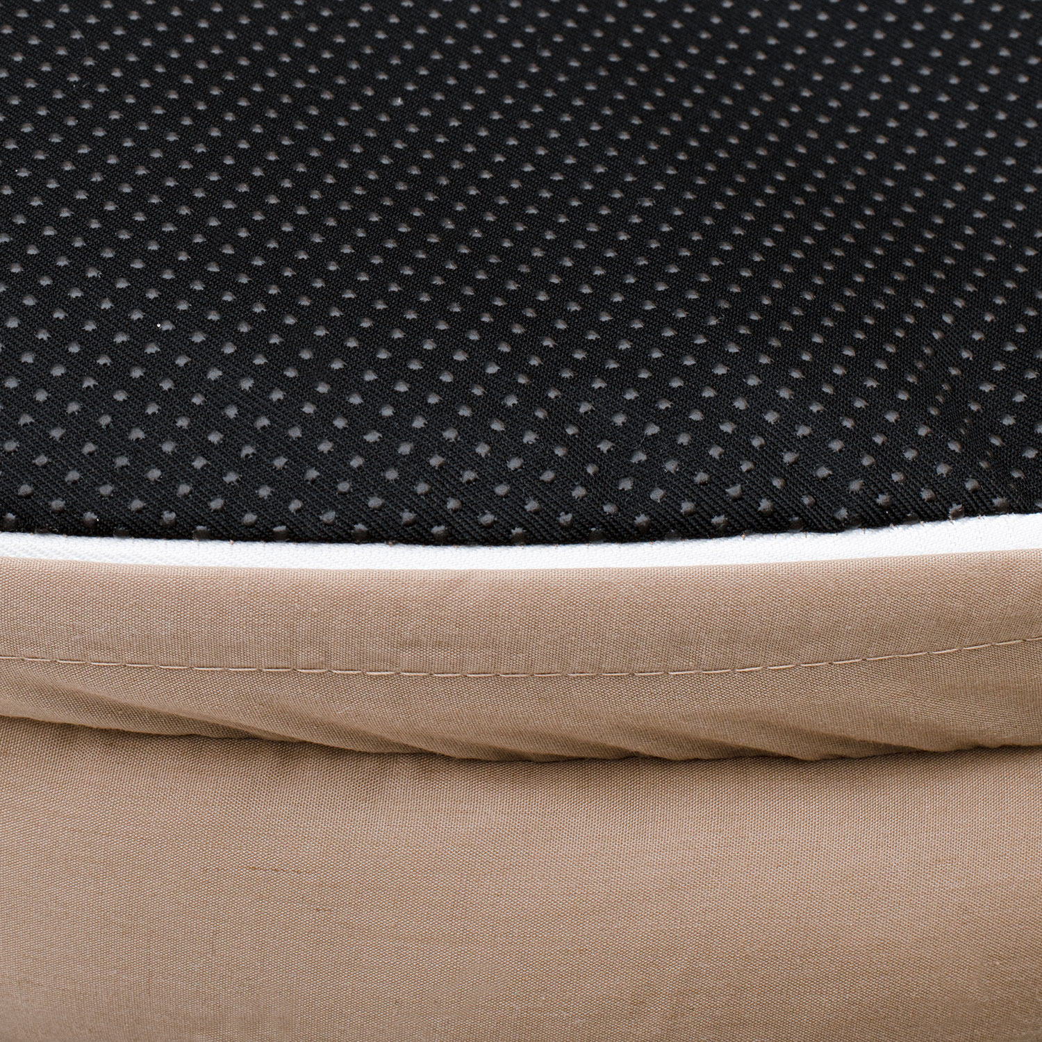 Primer plano de una tela beige y negra estampada. Borde blanco separa capas.