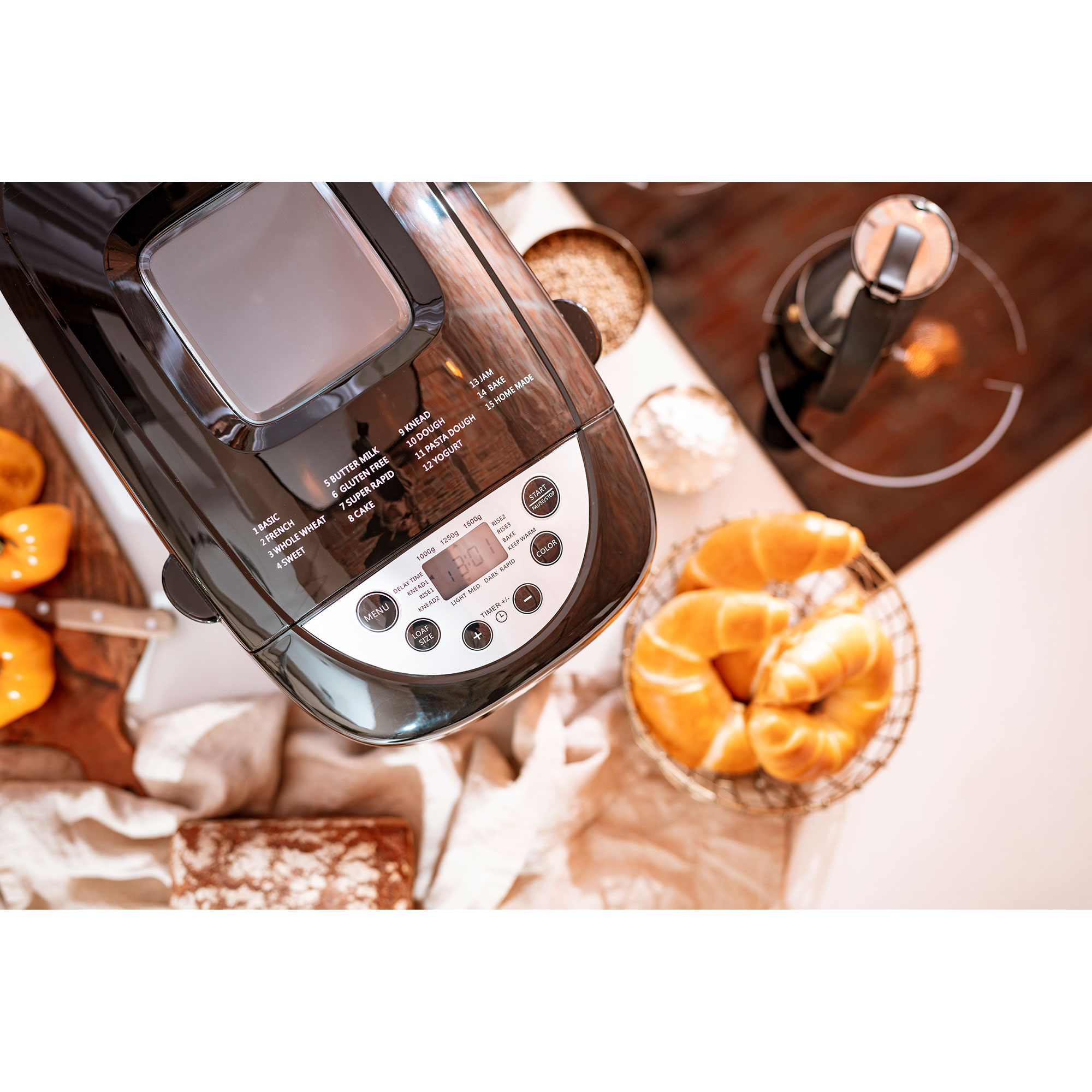 Schwarzer Brotbackautomat mit Display. Croissants und Brot sind in der Szene.