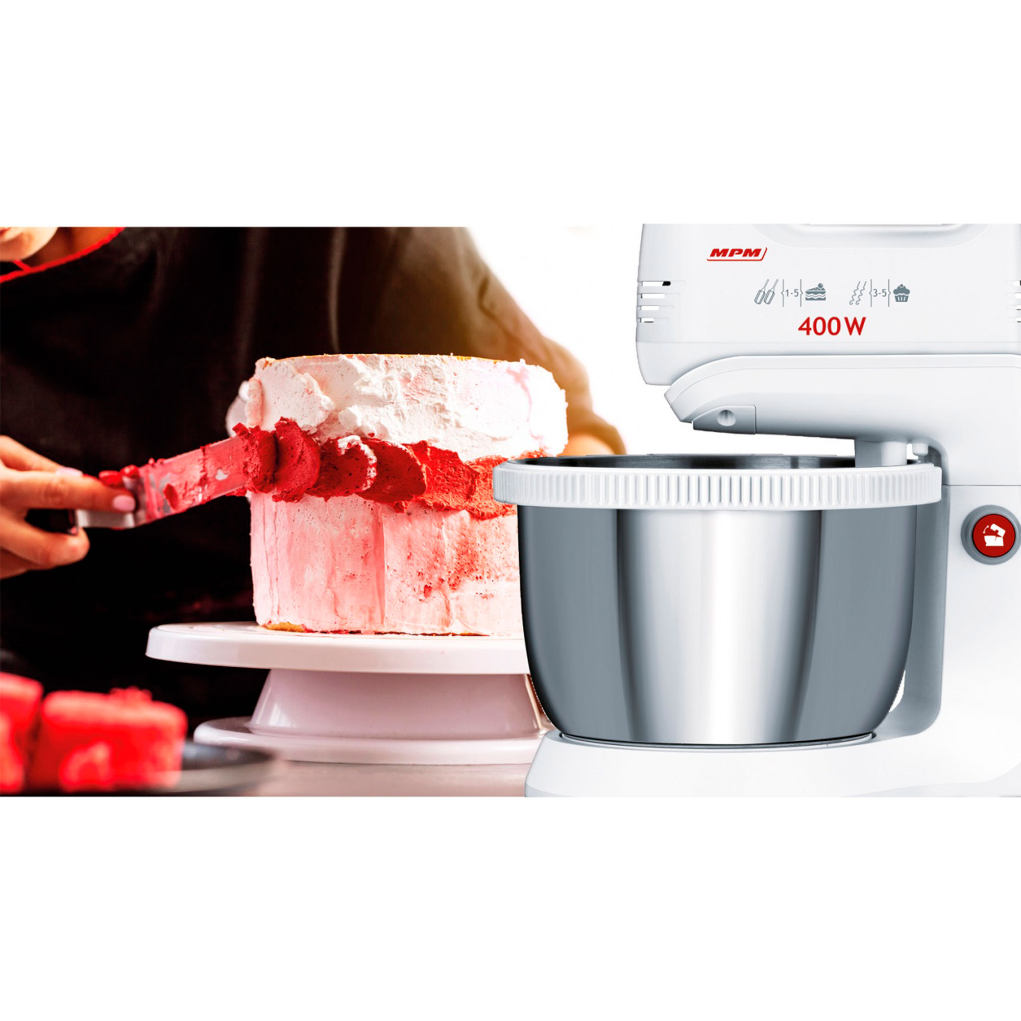 Ciasto dekorowane czerwonym lukrem. Biały stojak i mikser po prawej stronie.