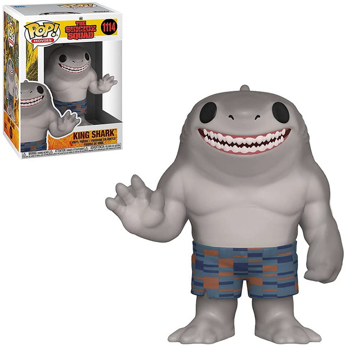Figura Funko Pop di King Shark e scatola. La figura è grigia con pantaloncini blu.