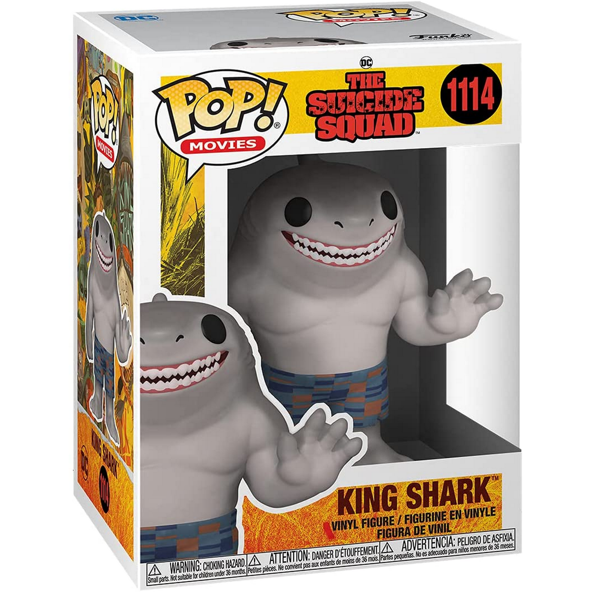Una figura di King Shark in una scatola. La figura è grigia con pantaloncini blu, la scatola ha del testo.