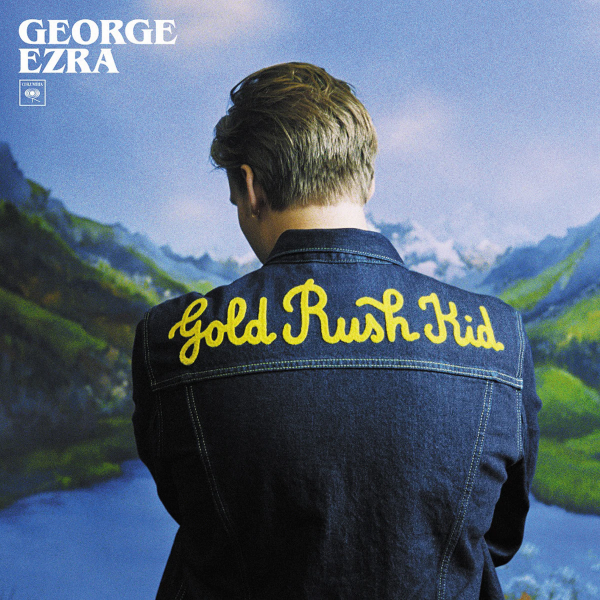 Copertina dell'album, George Ezra, Gold Rush Kid, giacca di jeans, cielo blu e montagne.