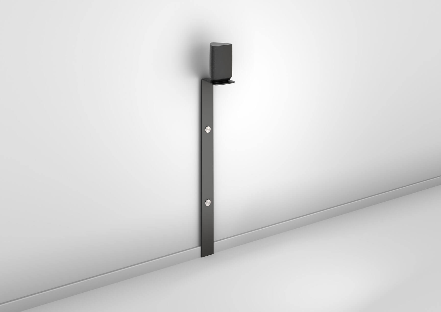 Schwarze Lautsprecher-Wandhalterung an weißer Wand. Vertikaler Balken und kleines Regal.