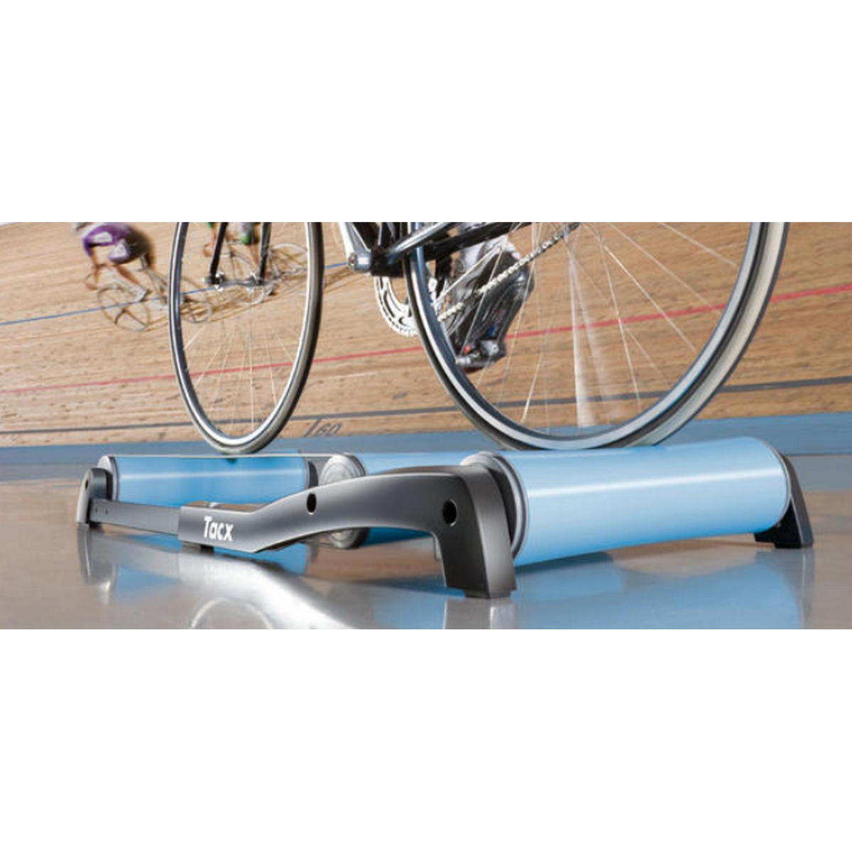 Ein Fahrrad auf einem Trainer, mit zwei Radfahrern im Hintergrund.