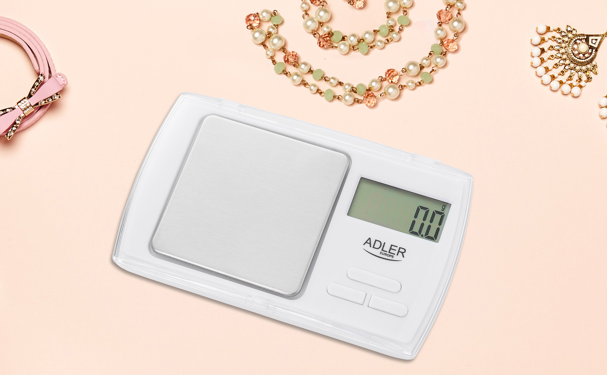 Báscula digital con joyas y accesorios. Balanza blanca, mostrando 0,0.