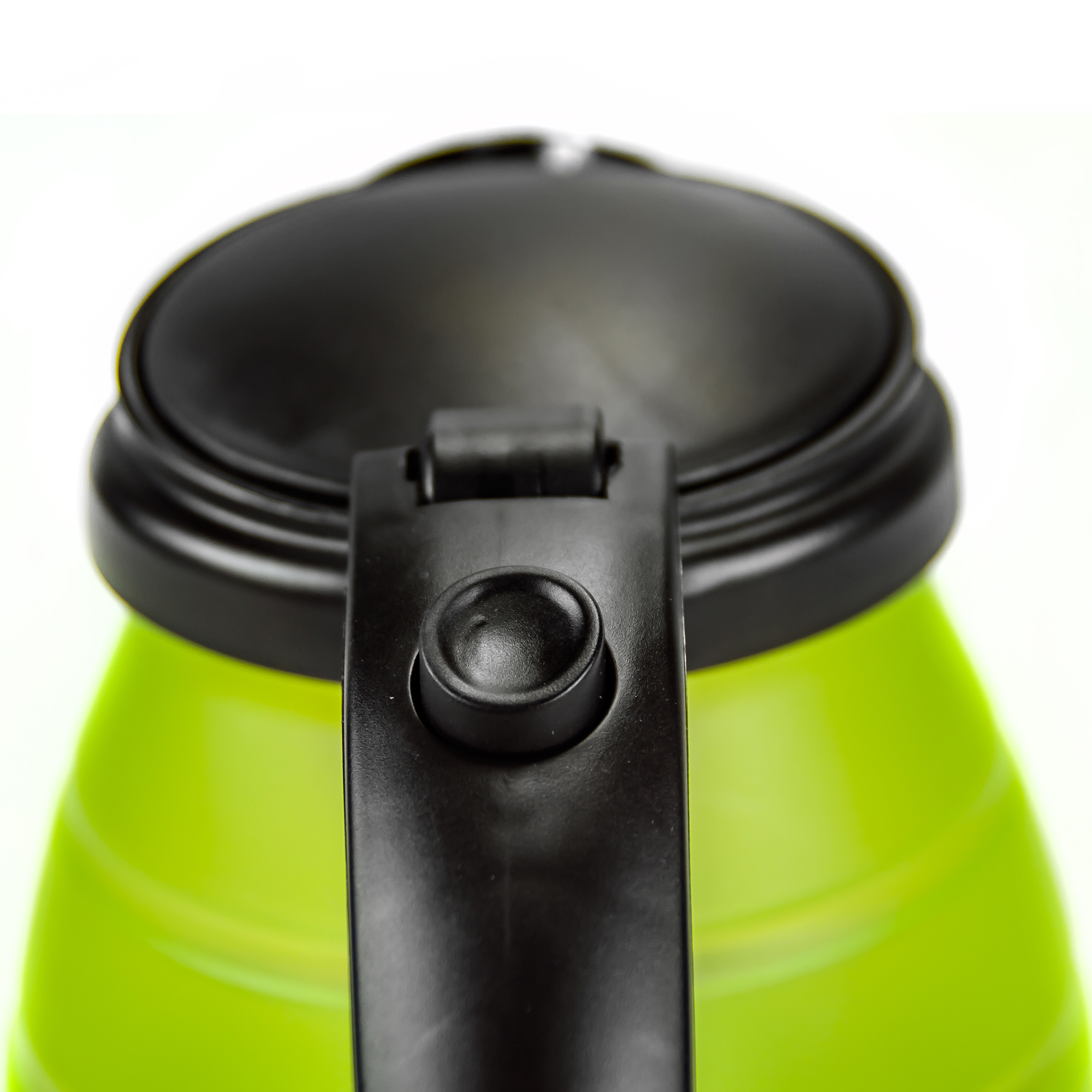 Zbliżenie na zielony i czarny uchwyt czajnika elektrycznego oraz czarną pokrywkę. Czajnik jest zielony.