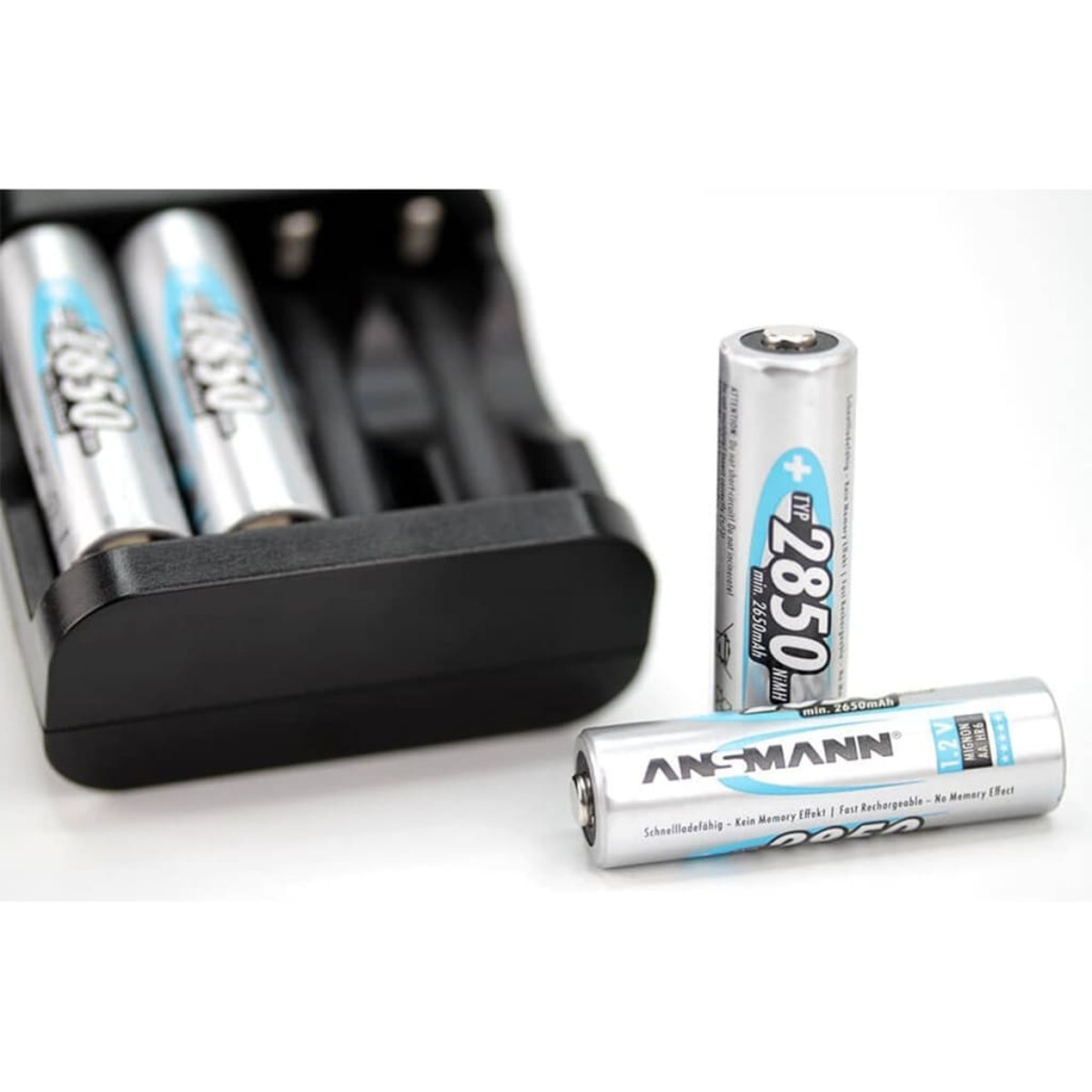 Drei zylindrische Batterien mit Ladestation. Weißer Hintergrund.